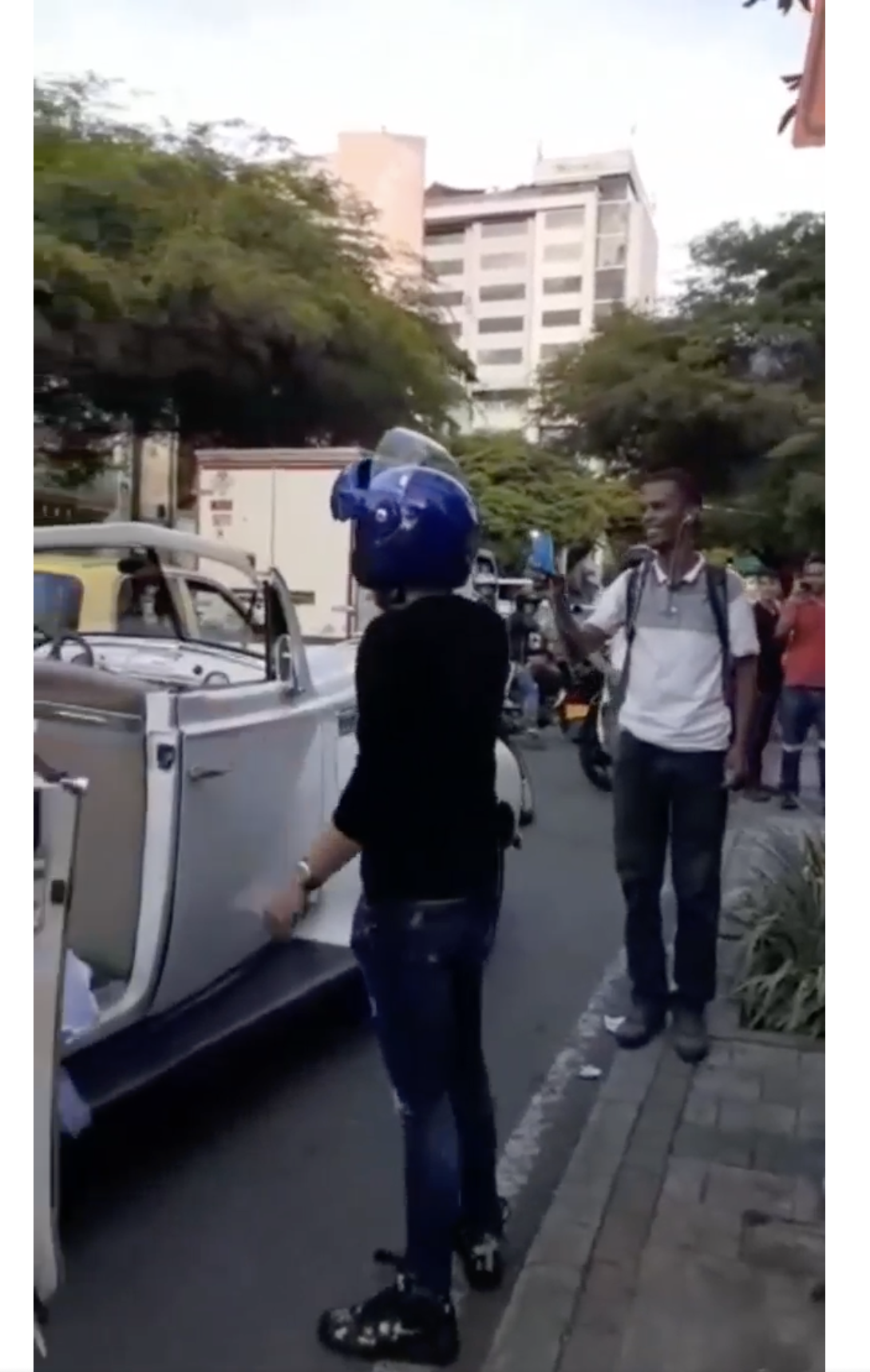Der Motorradfahrer und ein Schaulustiger, der den Vorfall mit der Kamera aufnahm, sind am Straßenrand in Medellin, Kolumbien, zu sehen | Quelle: facebook.com/maspopulareventos