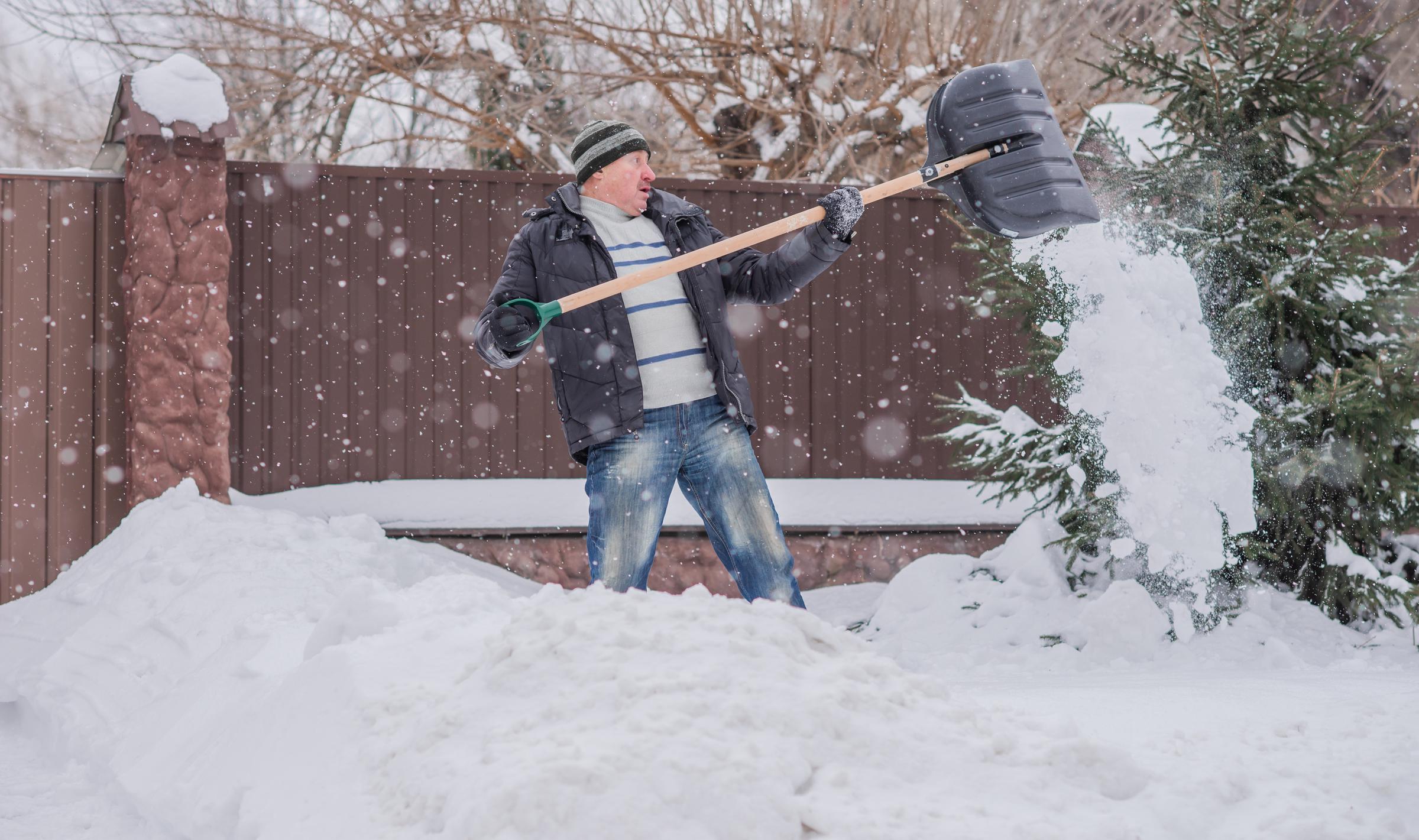 Man clearing snow in the winter | Source: Shutterstock