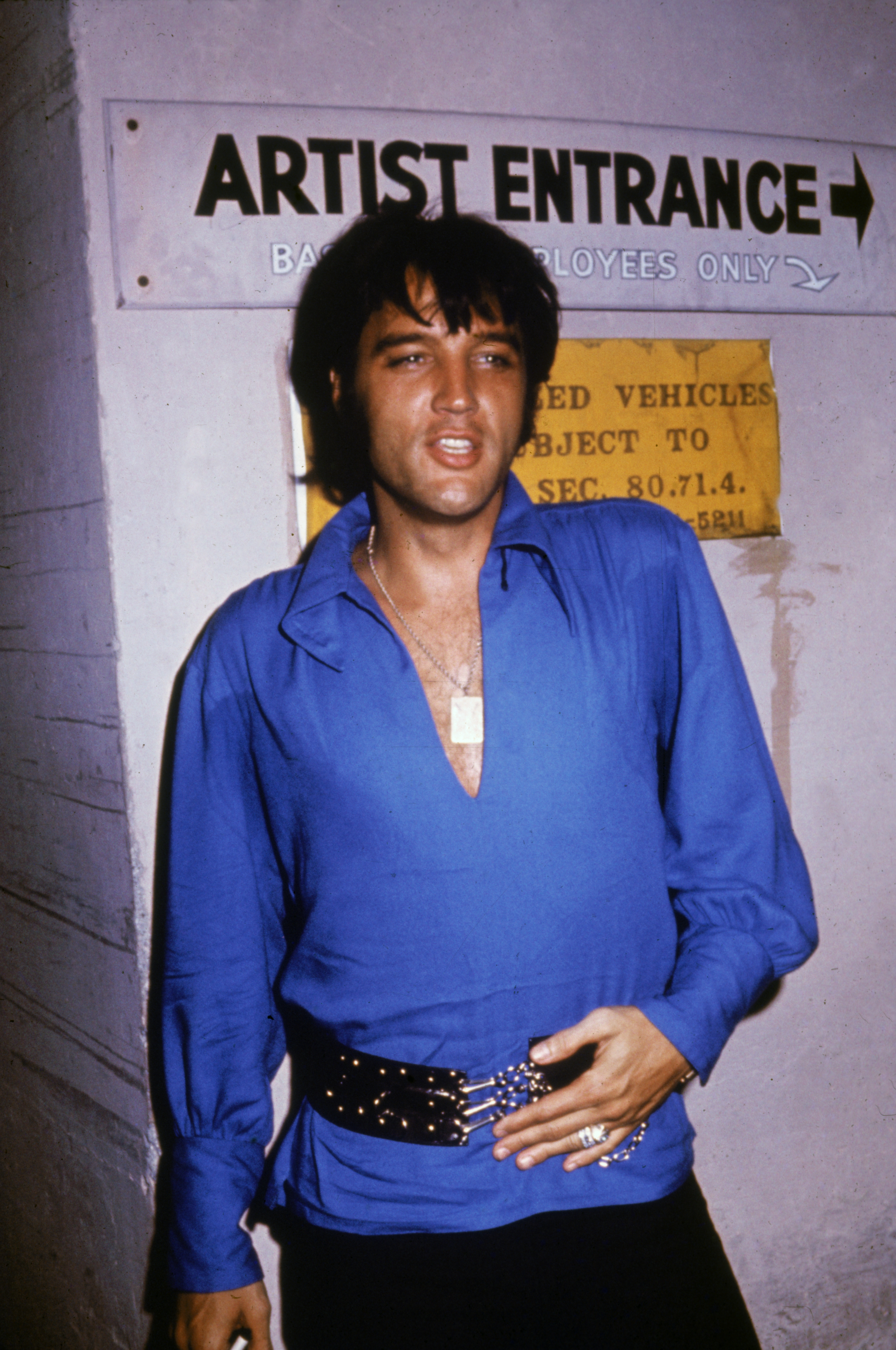 Elvis Presley stands backstage in a concert venue. | Source: Getty Images