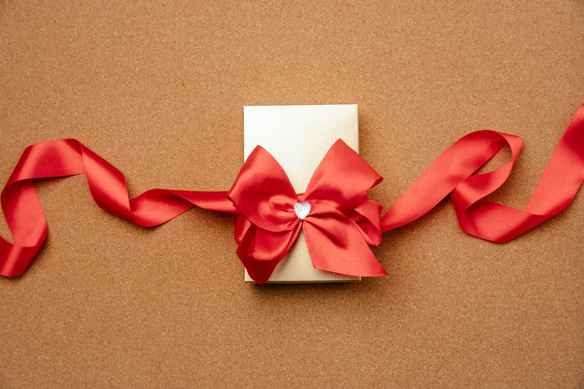 A small gift box decorated with a red ribbon | Source: Pexels