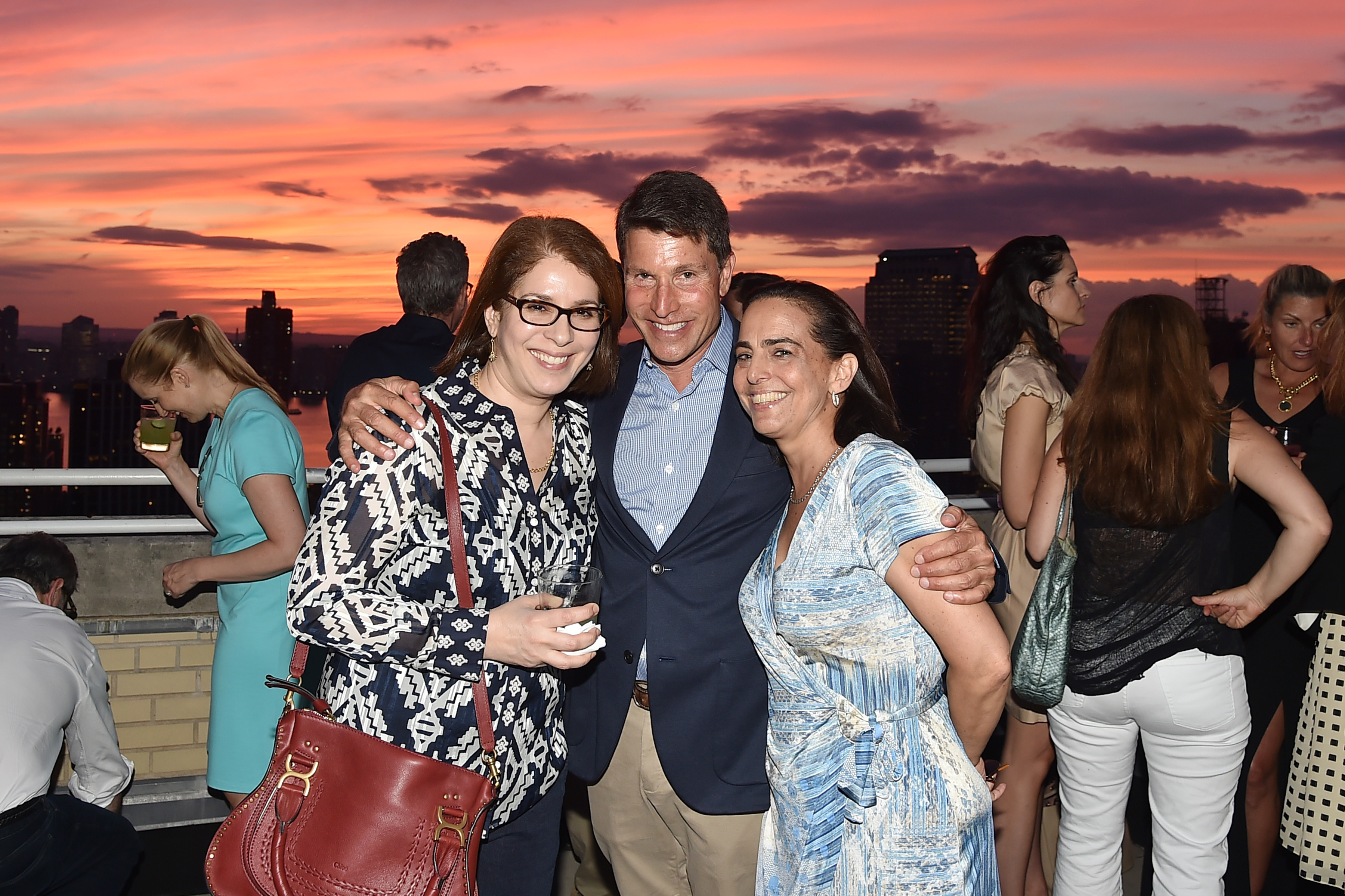 Neda Morvillo posing for a picture with guests at the Summer Birthday Cocktails For Lawrence Kaplan event in New York City on June 21, 2018 | Source: Getty Images