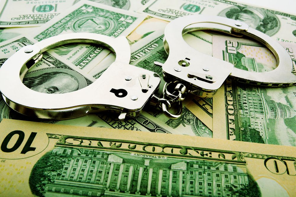 Handcuffs lying on money. | Source: Shutterstock 