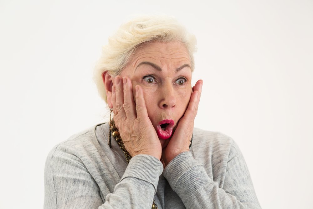 Una mujer mayor sorprendida son las manos sobre su rostro. | Foto: Shutterstock