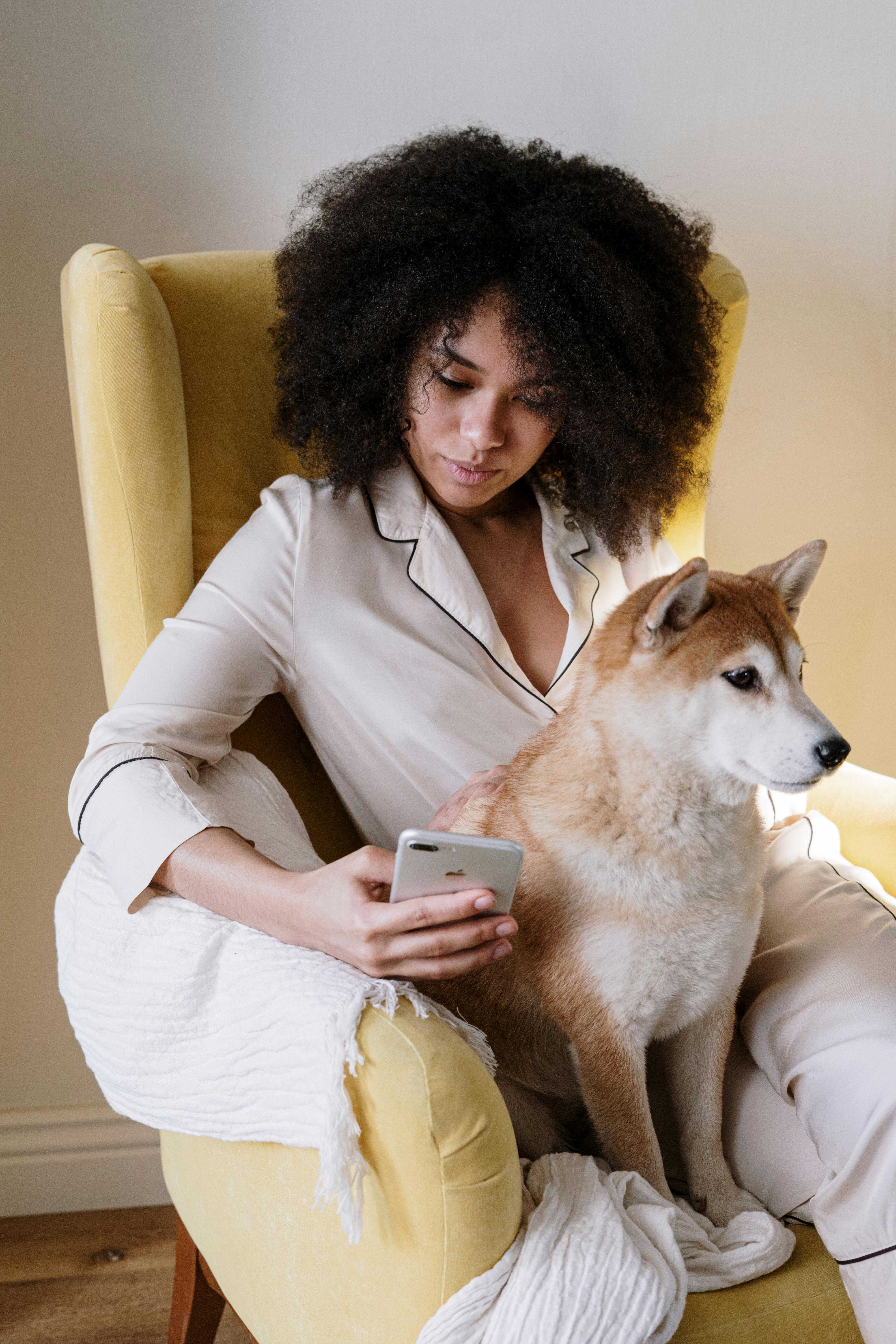 A woman in pajamas sitting with her dog | Source: Pexels