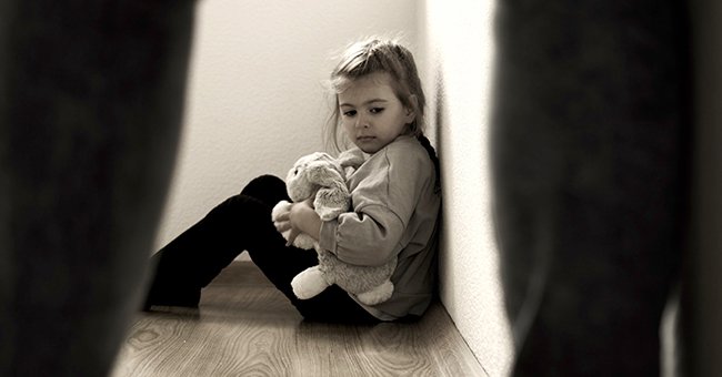 Niña sentada en el piso con un peluche en los brazos. | Foto: Shutterstock