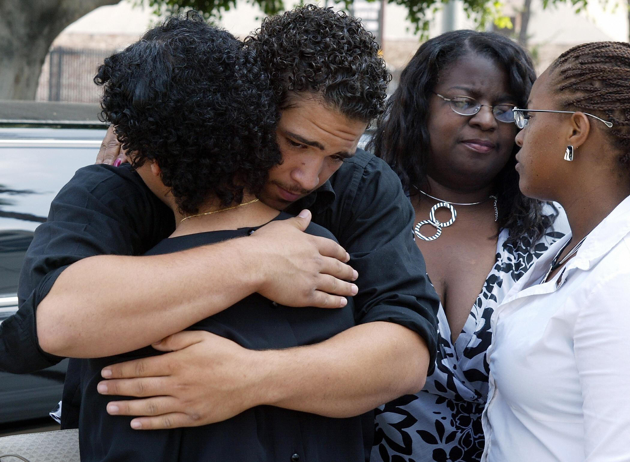 Corey Robinson comforts his sister Alexandra (back to camera) with two of Ray Charles' other daughters Raenee and Raeshan close by after viewing the open casket of the legendary musician, on June 17, 2004, in Los Angeles | Source: Getty Images