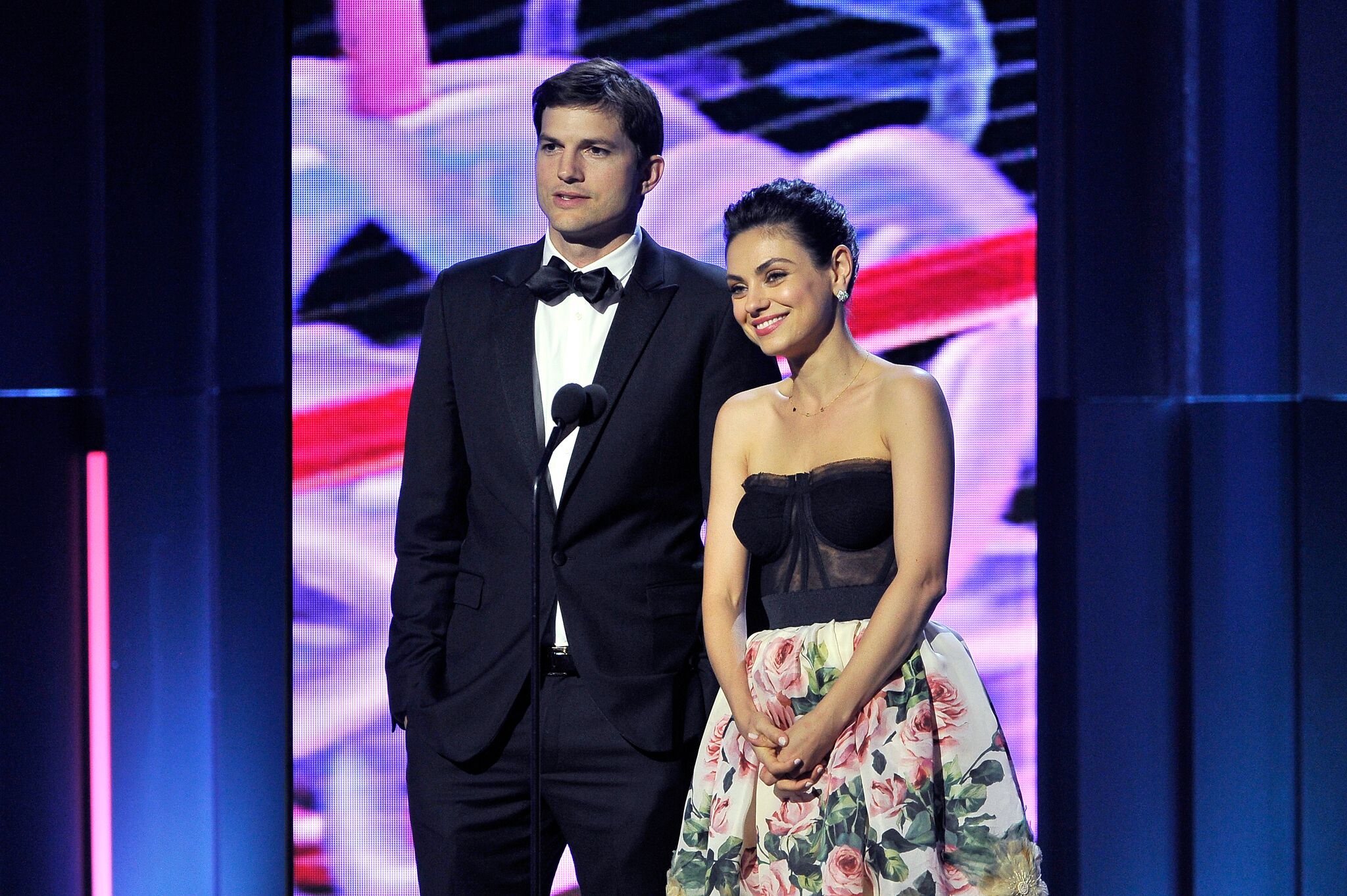 Ashton Kutcher (L) and Mila Kunis speak onstage during the 2018 Breakthrough Prize at NASA Ames Research Center | Getty Images