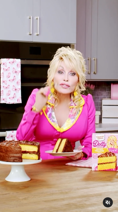A screenshot of Dolly Parton demonstrating her ability to persuade fans to try the yellow cake in a video. | Source: Instagram/dollyparton