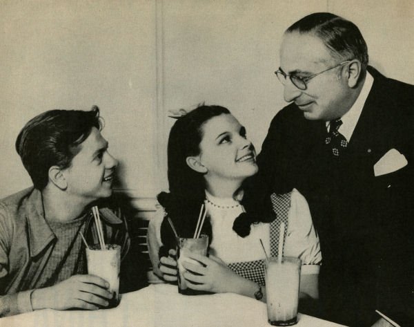 Publicity still released by MGM of Mickey Rooney, Judy Garland, and Louis B. Mayer. | Source: Wikimedia Commons.