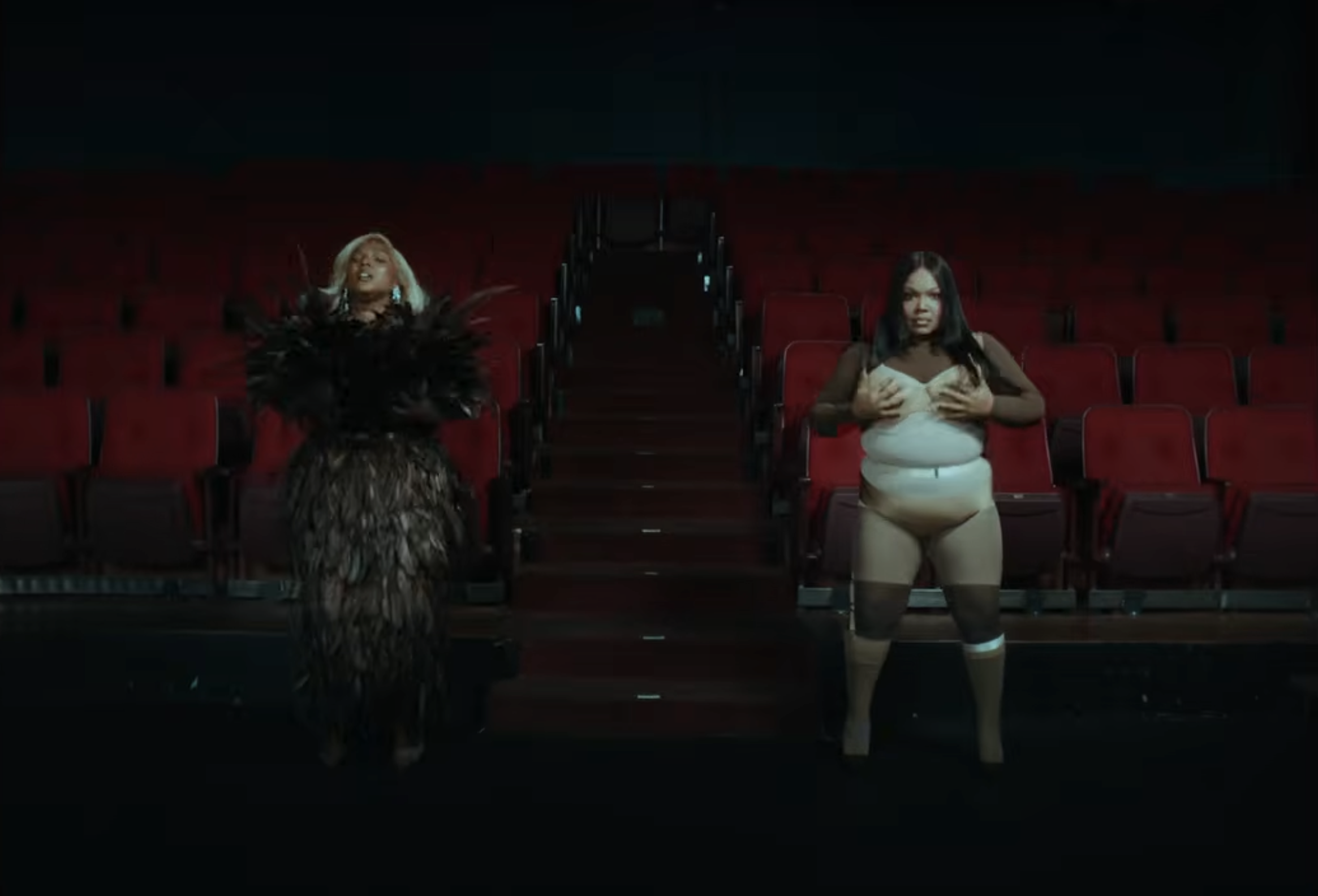 Both figures appear together on stage, occupying separate sides | Source: YouTube/Lizzo