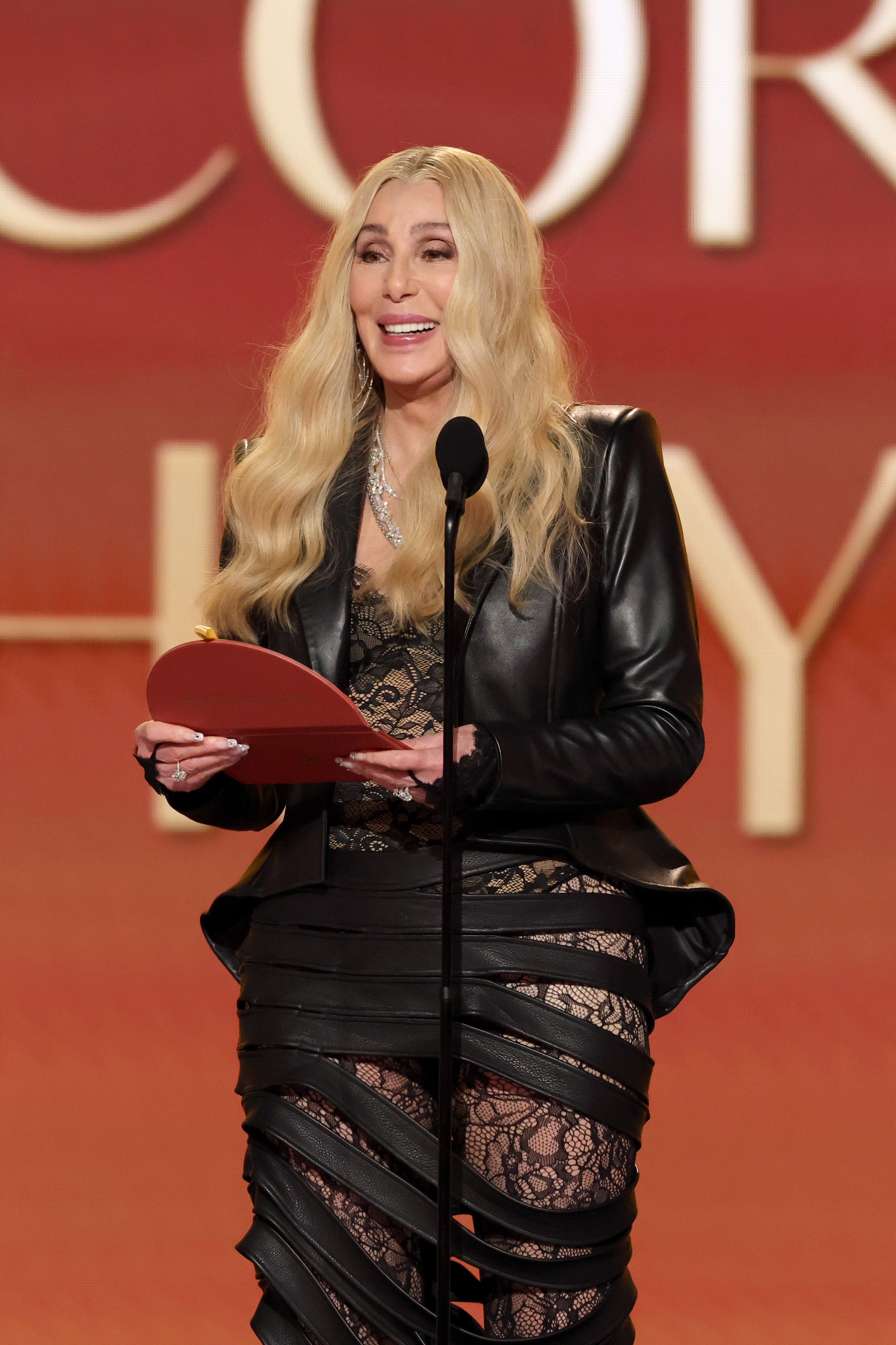 Cher smiles as she holds the awards envelope while speaking onstage at the 68th Grammy Awards | Source: Getty Images