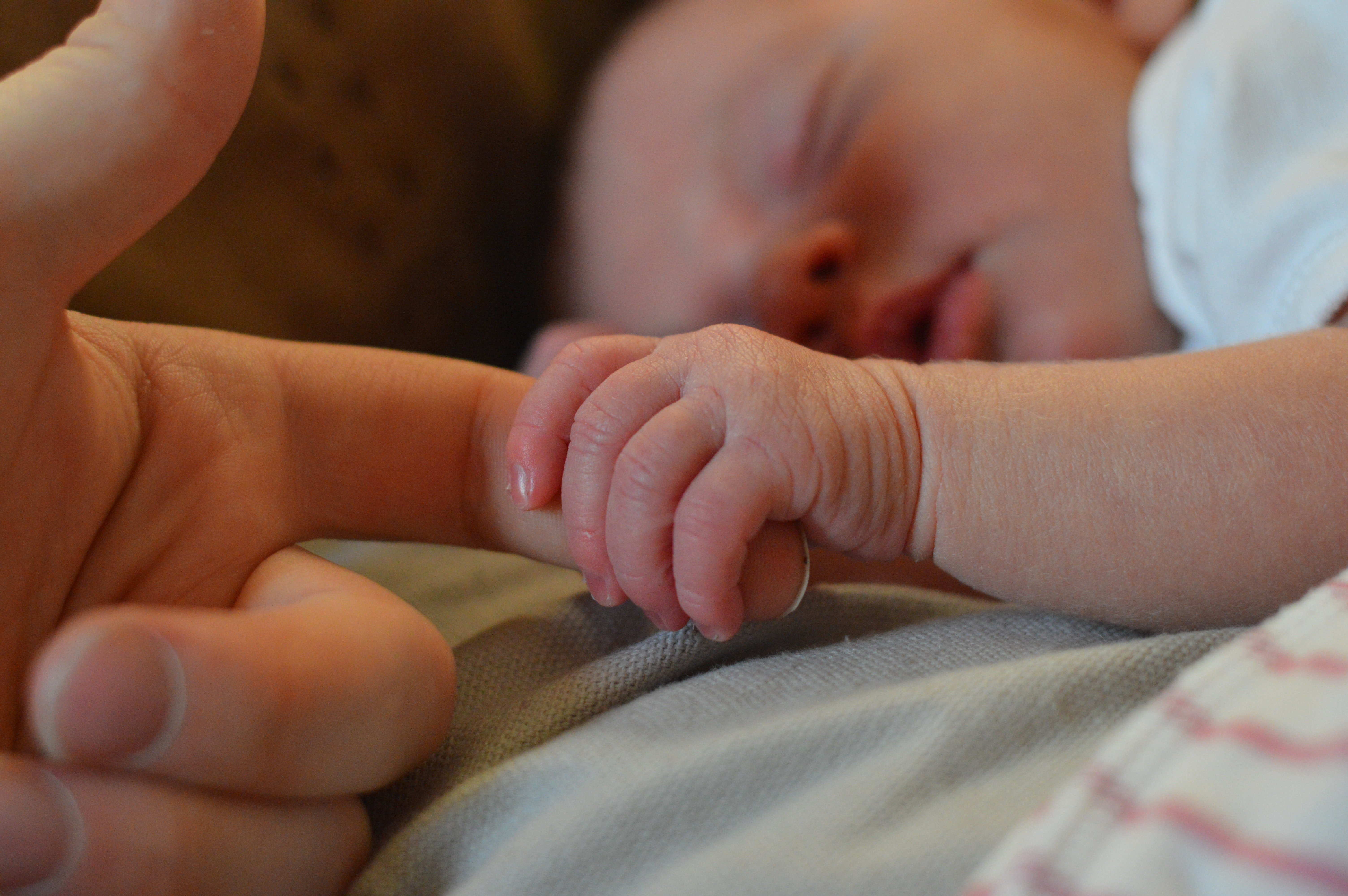 Bebé sosteniendo el dedo de su madre. | Foto: Pexels