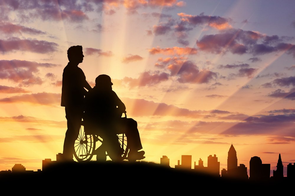 Hombre en silla de ruedas y acompañante. | Foto: Shutterstock