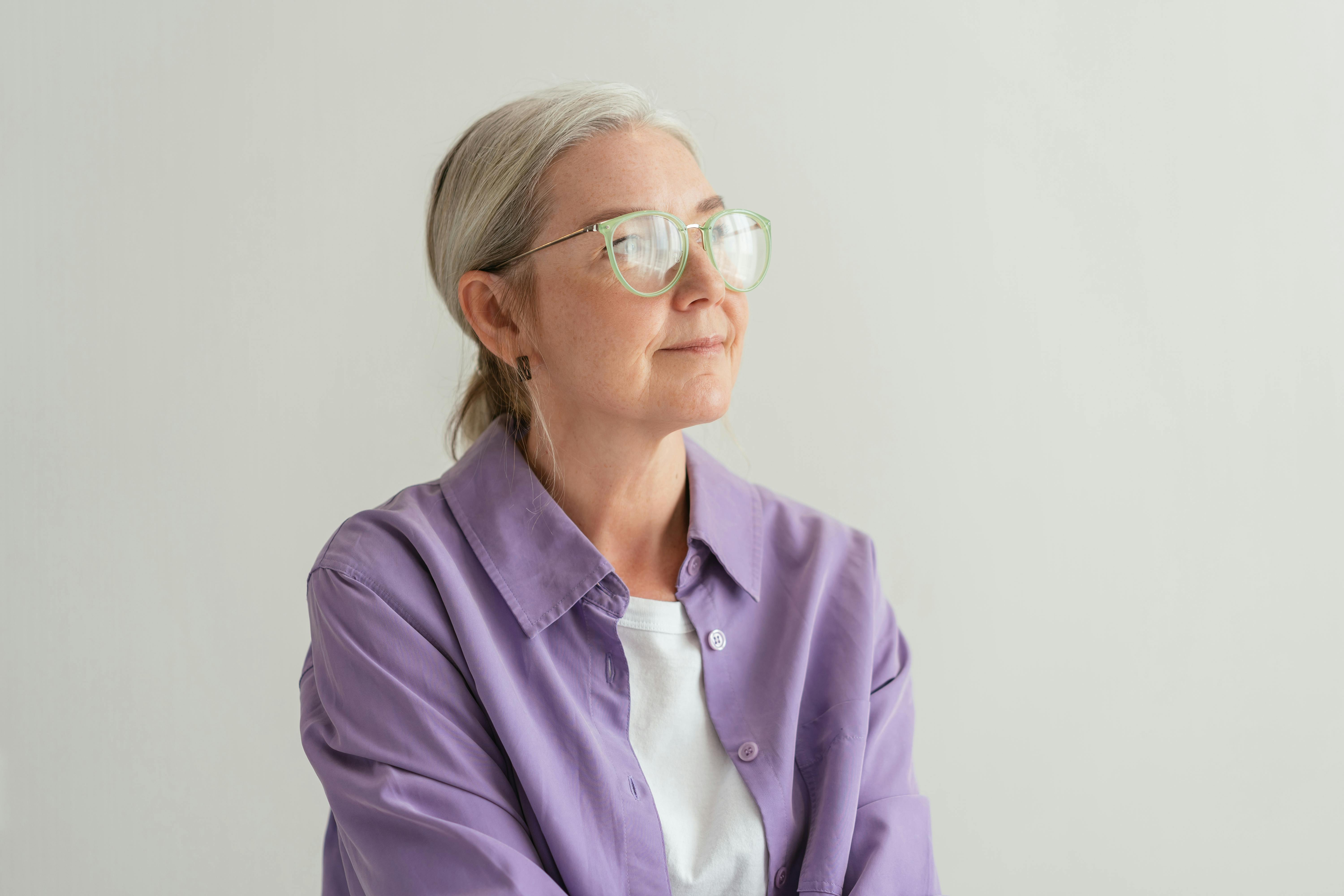 A woman wearing a purple button-down polo layered with a white shirt | Source: Pexels