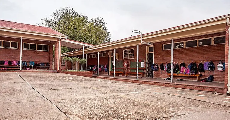 Ein Schulgebäude mit Rucksäcken. | Quelle: Shutterstock