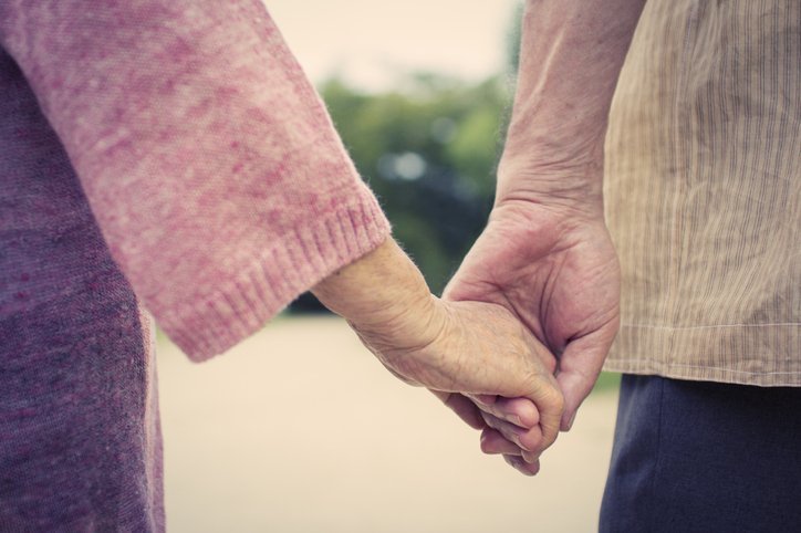 A picture of an elderly couple holding hands as they take a walk. | Photo: Getty Images