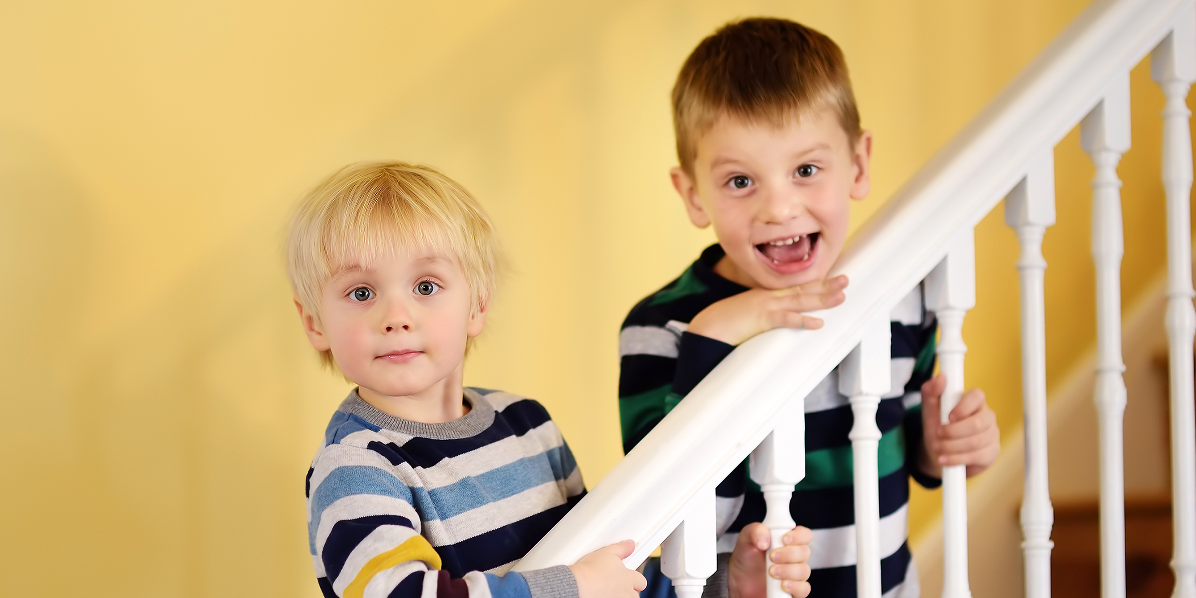 Two boys standing on a staircase | Source: Shutterstock