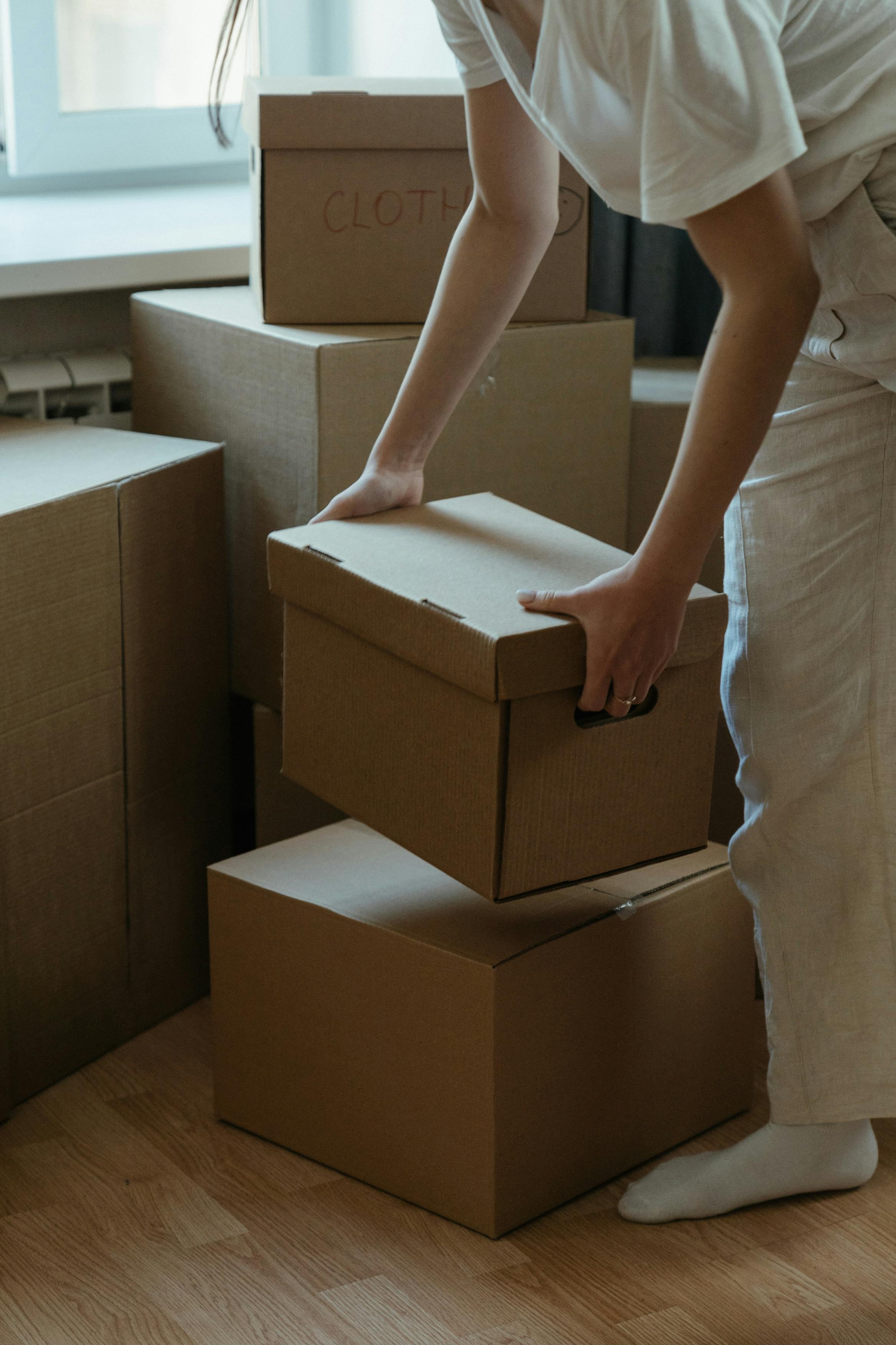 Woman stacking boxes | Source: Pexels