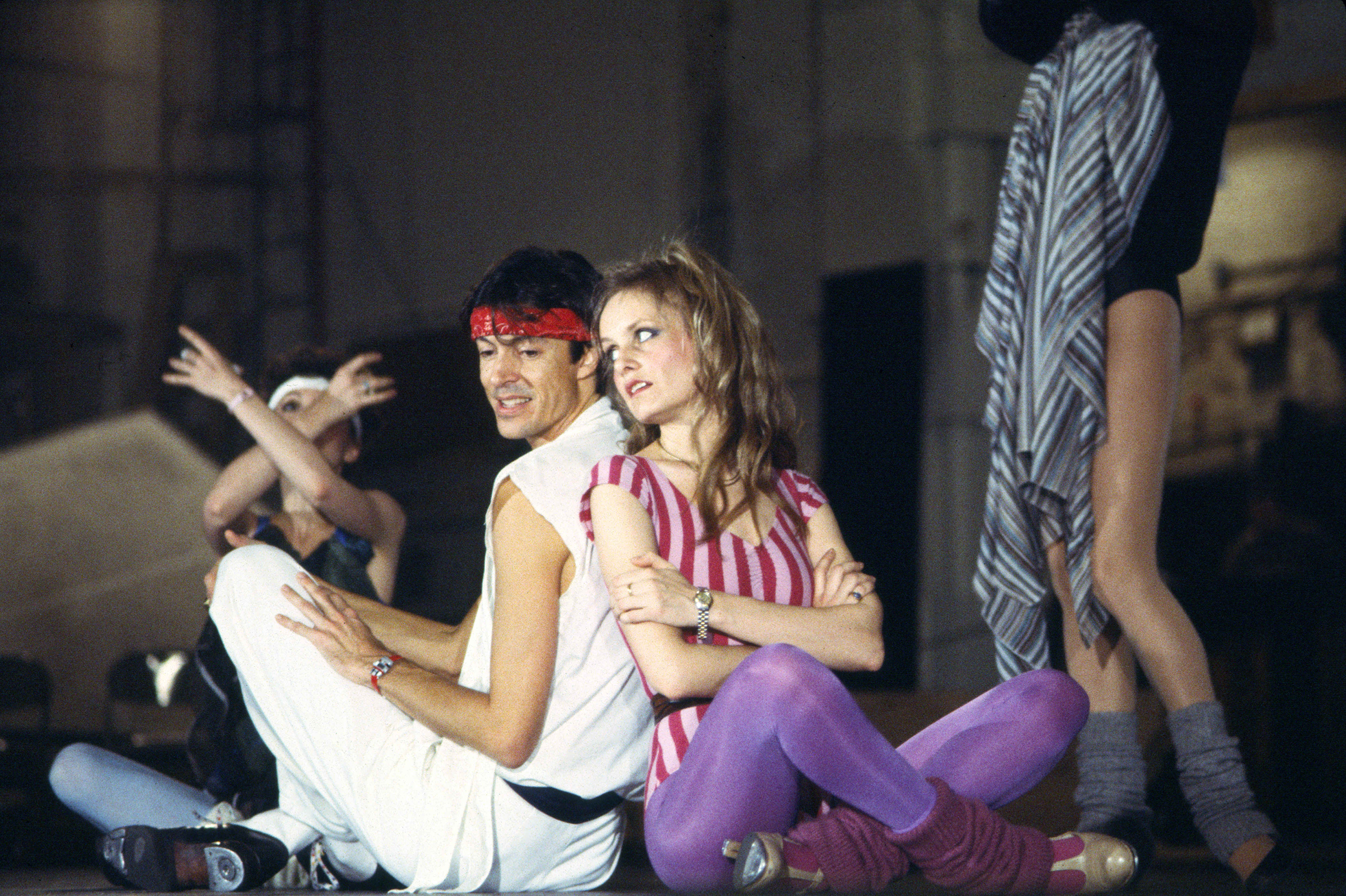 Tommy Tune and Twiggy seated back to back onstage, during a press call at the St James Theater, in New York on January 13, 1983 | Source: Getty Images