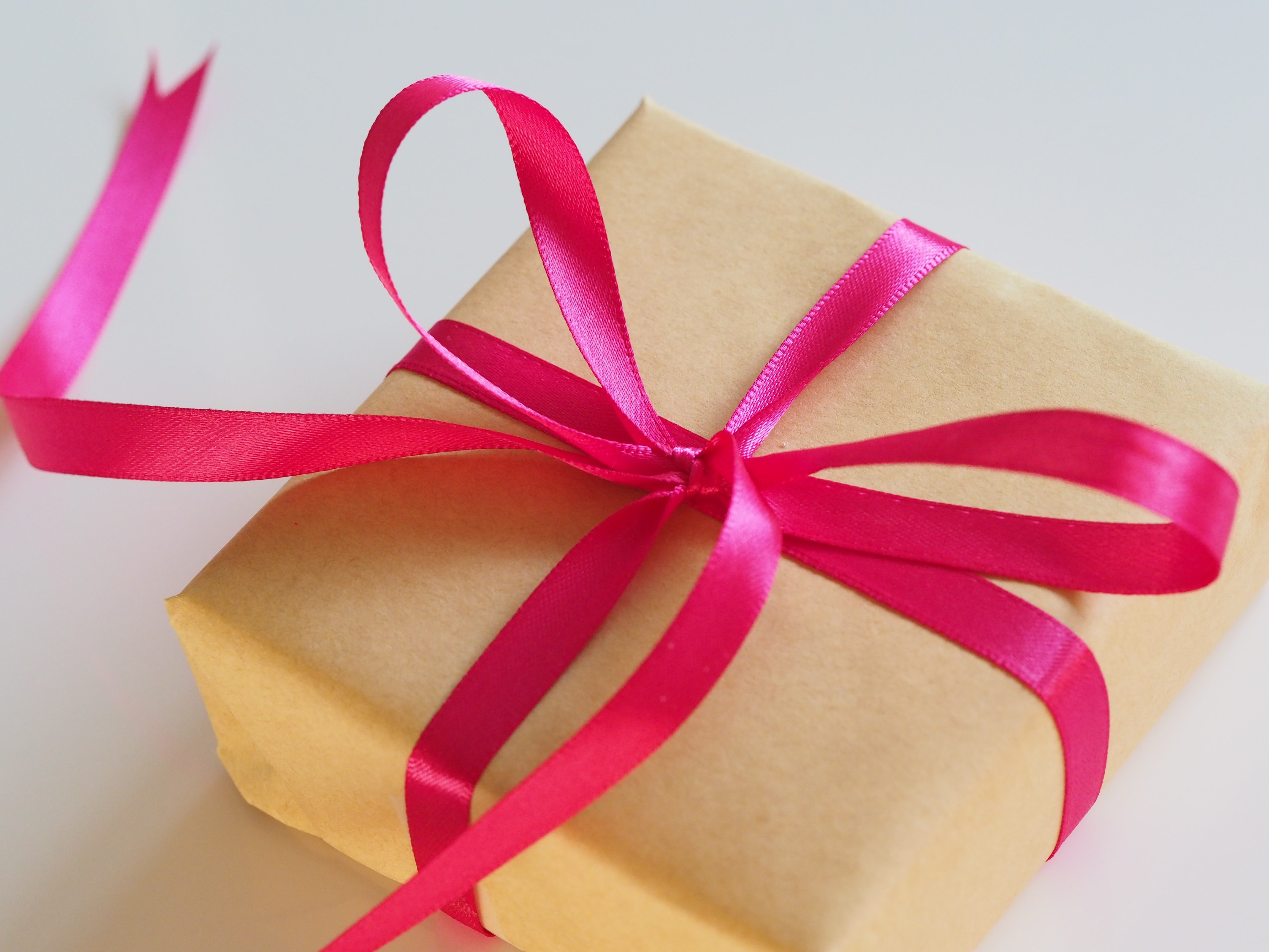Brown gift box with a red ribbon | Source: Unplash
