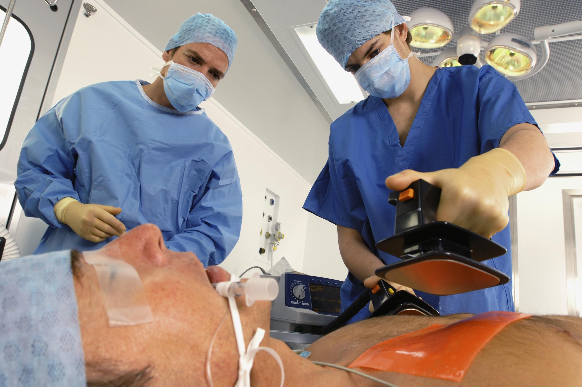 Doctors using defibrillator to resuscitate male heart attack victim | Source: Getty Images