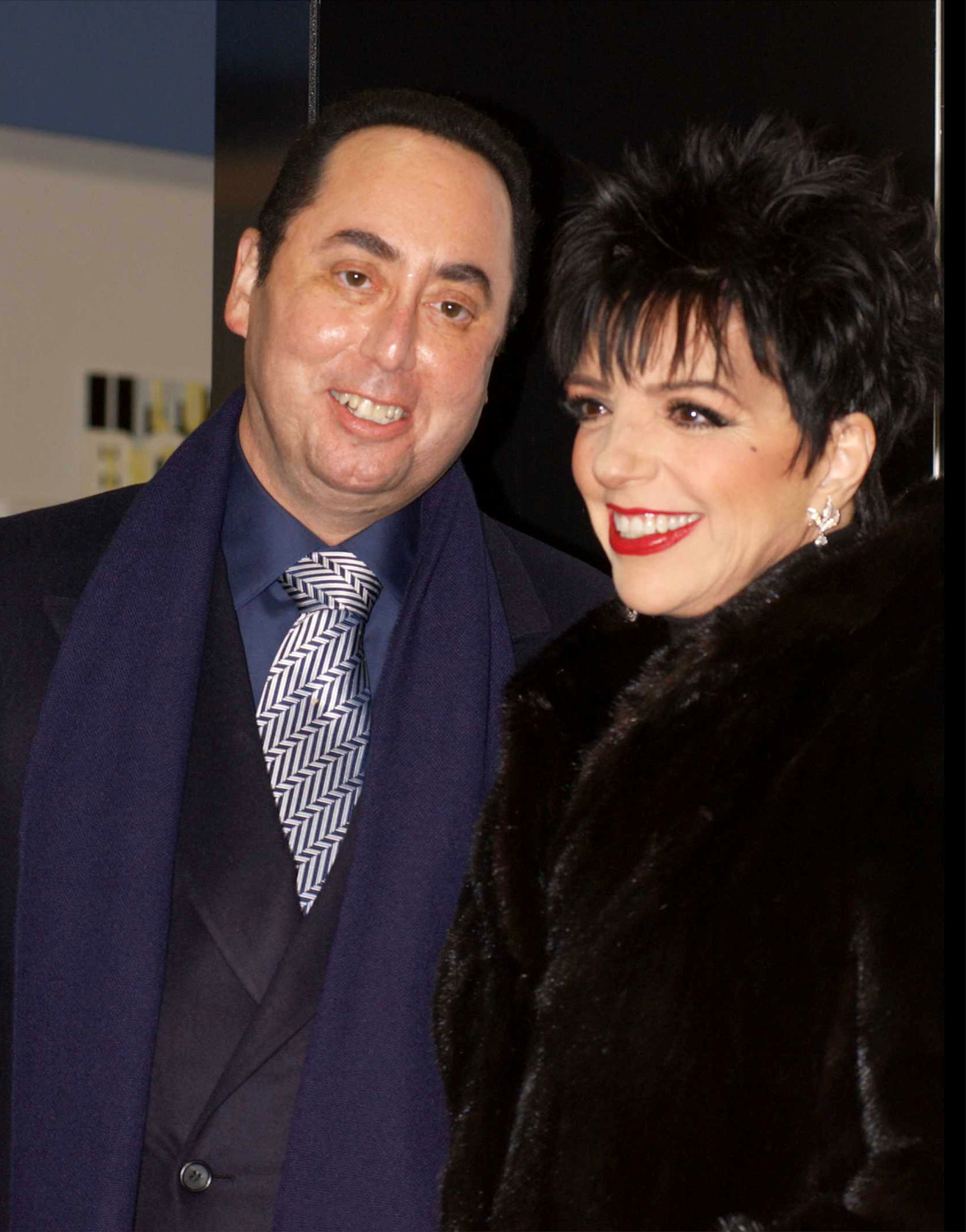 Newlyweds David Gest and Liza Minnelli arrived together at Tower Records in New York City on October 29, 2002, for an in-store appearance celebrating the release of her album "Liza's Back." Gest coordinated his dark suit with a blue scarf and patterned tie, while Minnelli smiled beside him in a black fur coat, capturing the couple during the same year their highly publicized marriage began.