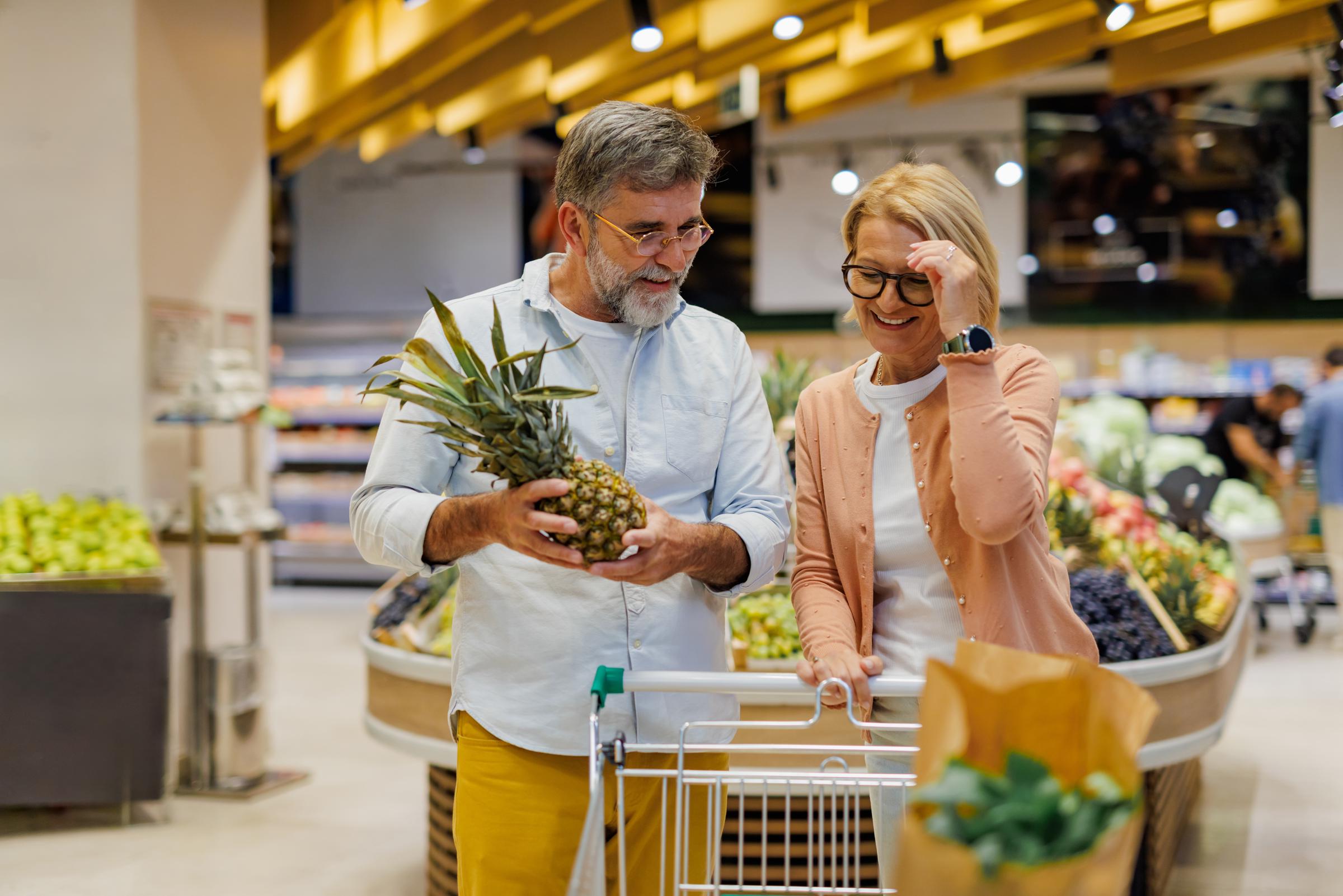 A couple in the produce section of a grocery | Source: Shutterstock