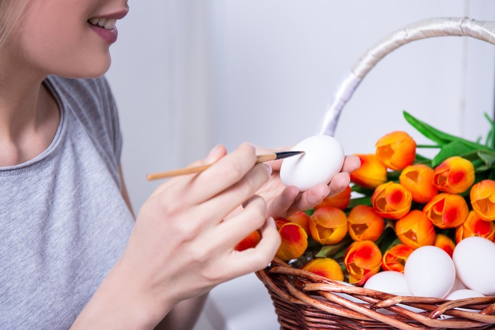 Close up of a young woman painting Easter eggs | Source: Shutterstock