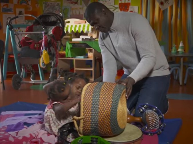 Brahima Ndiaye joue avec ses filles siamoises. | Photo:YouTube/BBC News