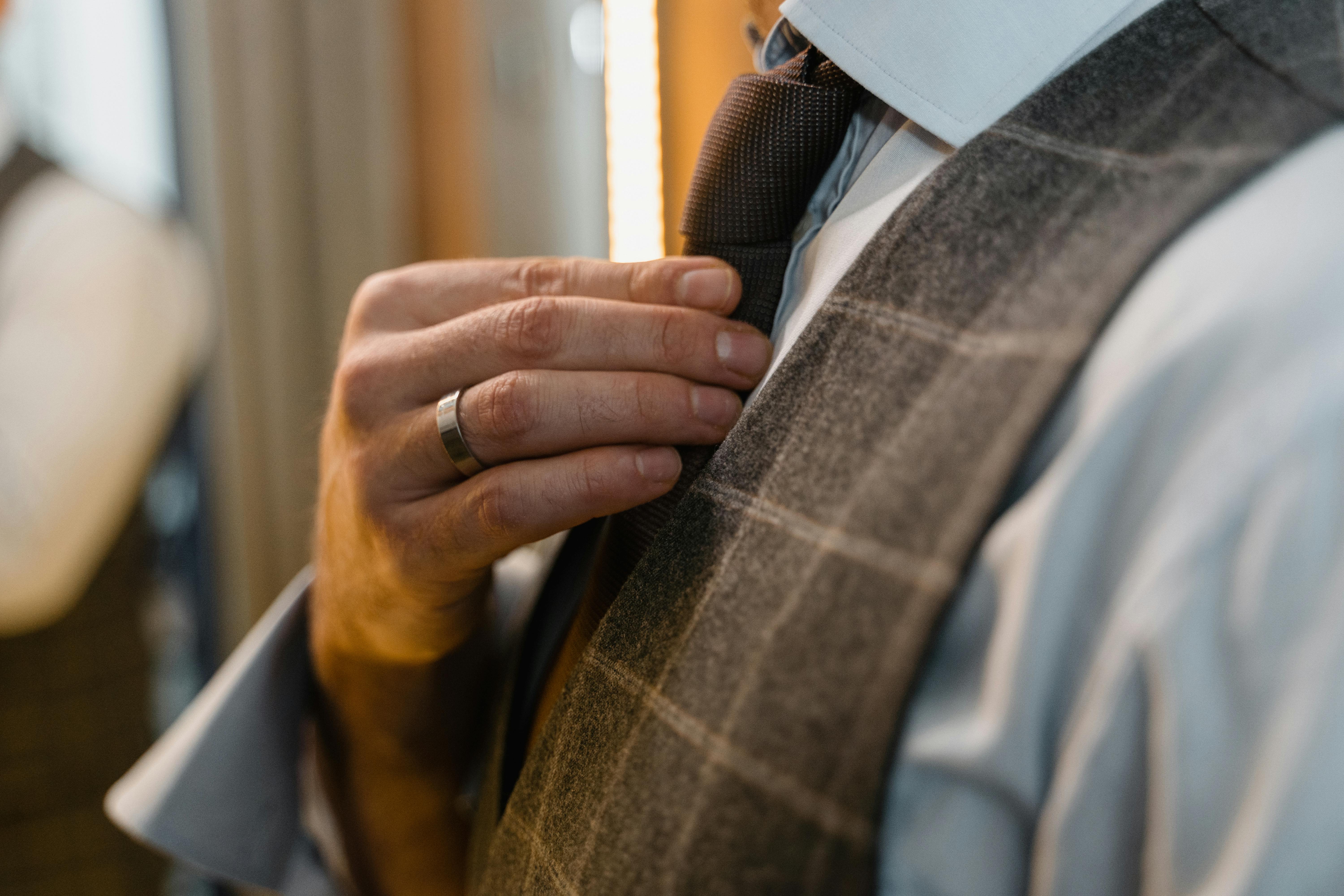A man getting dressed in his finest suit and tie | Source: Pexels