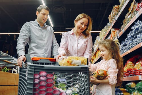 Man, woman and child in a supermarket | Source: Pexels