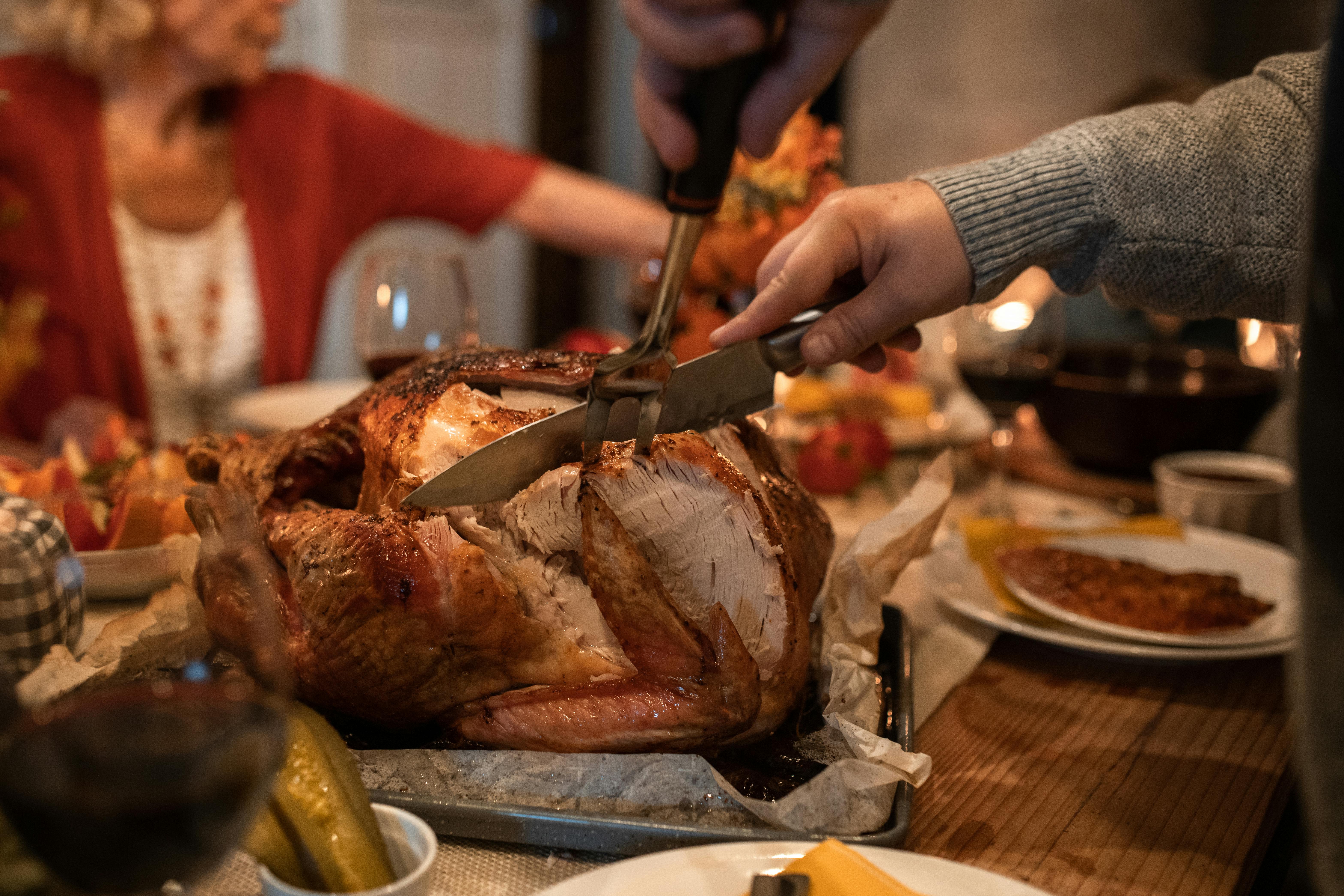 A person slicing meat on the table | Source: Pexels