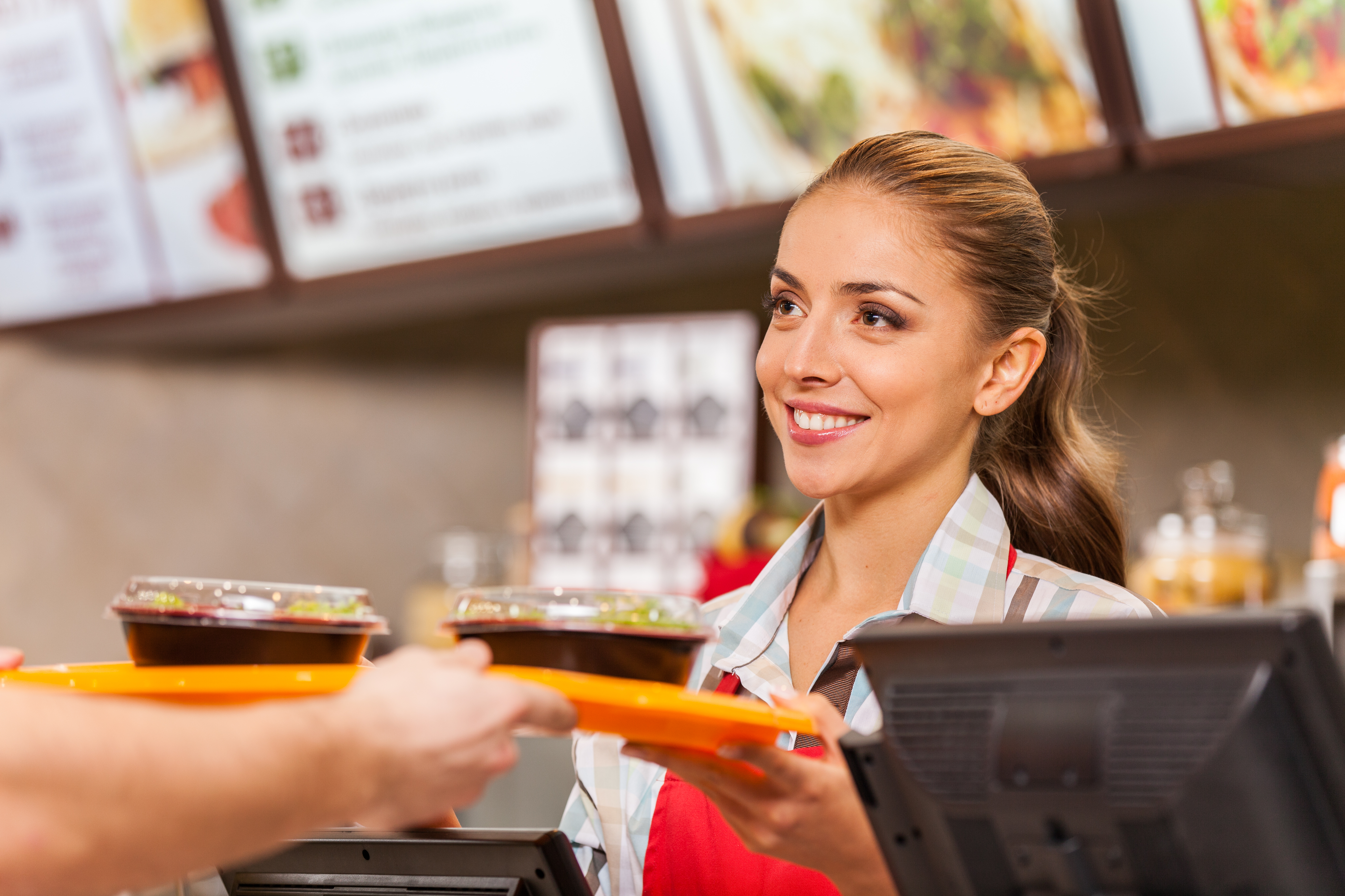 A waitress handing over some fast food | Source: Shutterstock