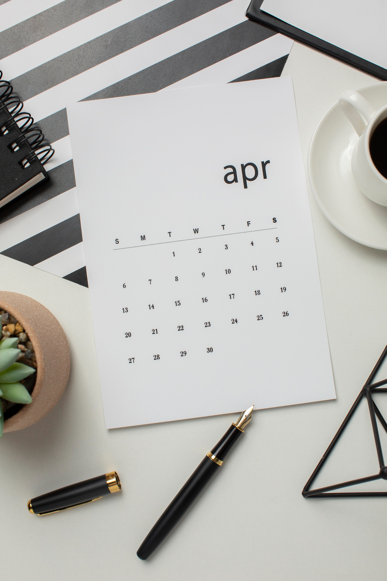 An April calendar page with a pen | Source: Freepik
