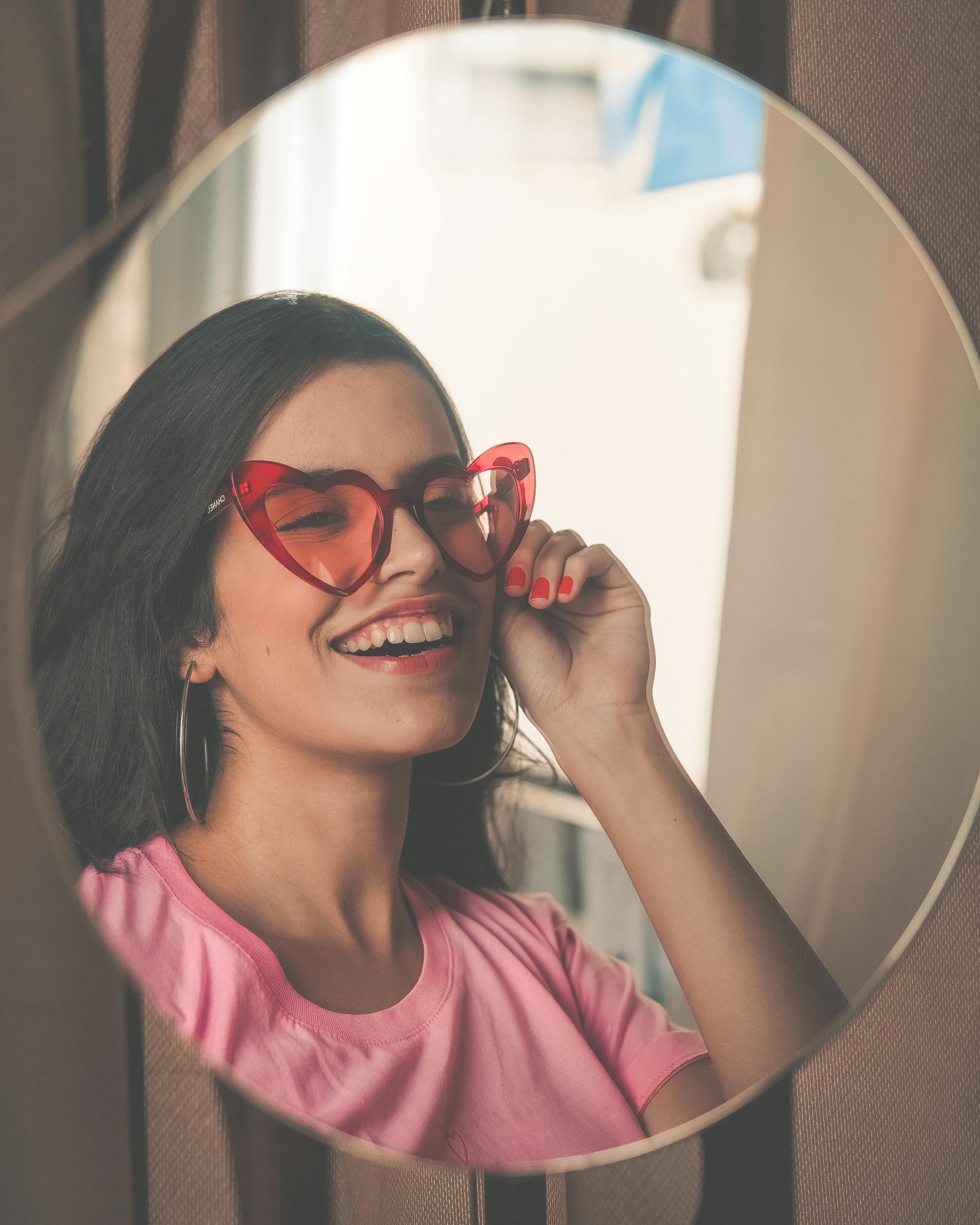 A woman smiling in a mirror | Source: Pexels