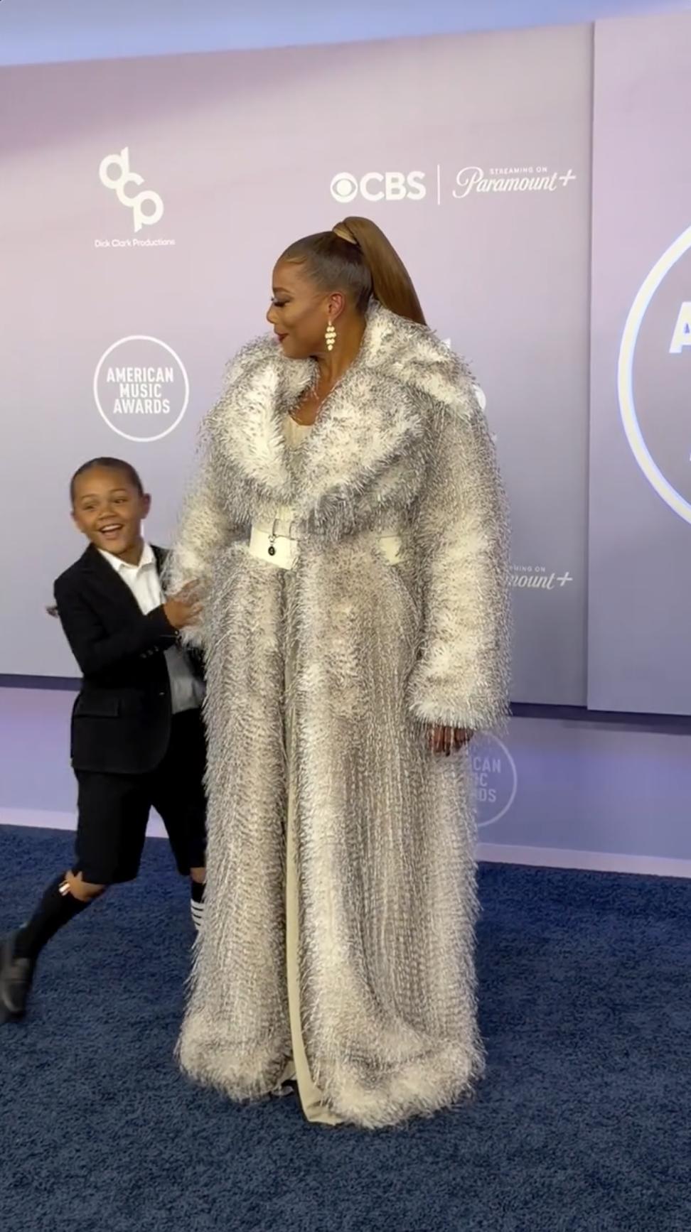 ebel Nichols Owens rushes toward Queen Latifah with a wide smile as she turns toward him during a candid family moment on the American Music Awards carpet in Las Vegas. | Source: Instagram/perezhilton