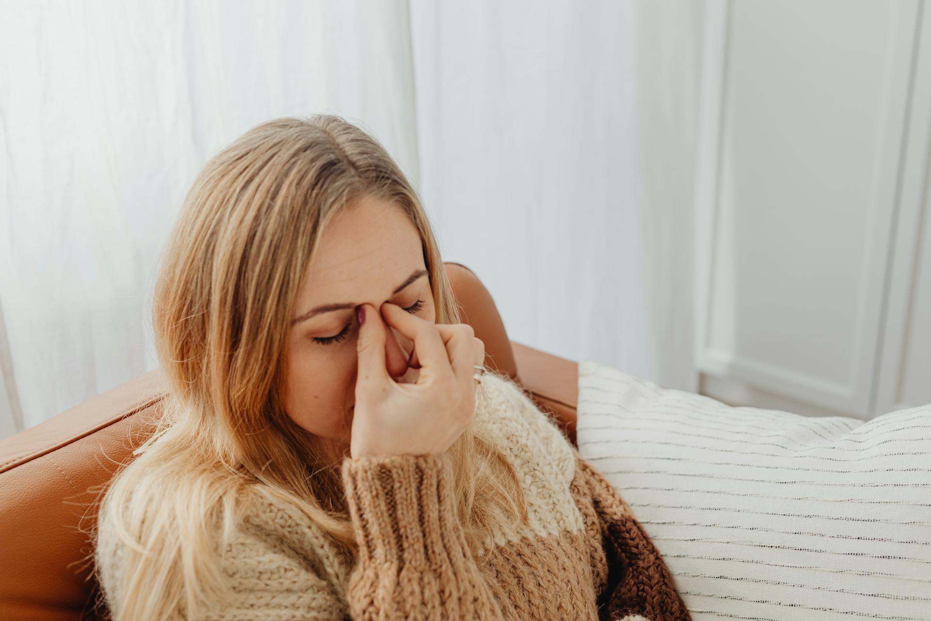 An anxious woman sitting on the couch | Source: Pexels