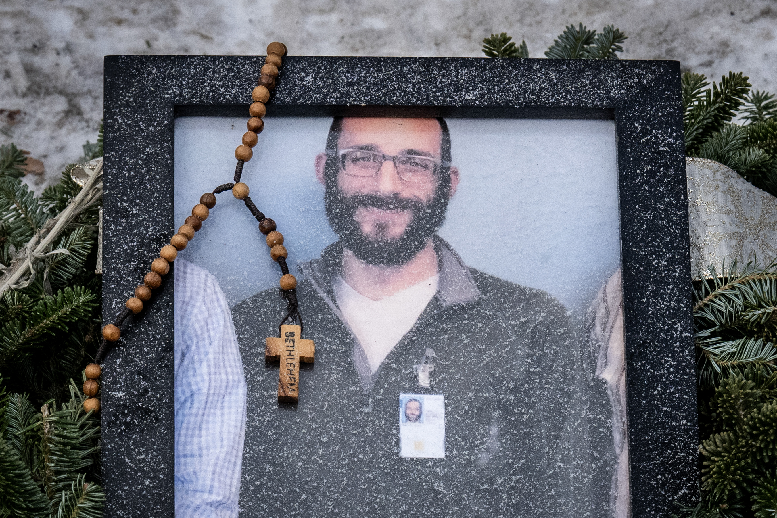 A rosary drapes a framed photograph of Alex Pretti, placed at a makeshift memorial near the location where he was fatally shot by federal immigration agents in Minneapolis, Minnesota, on January 24, 2026. | Source: Getty Images