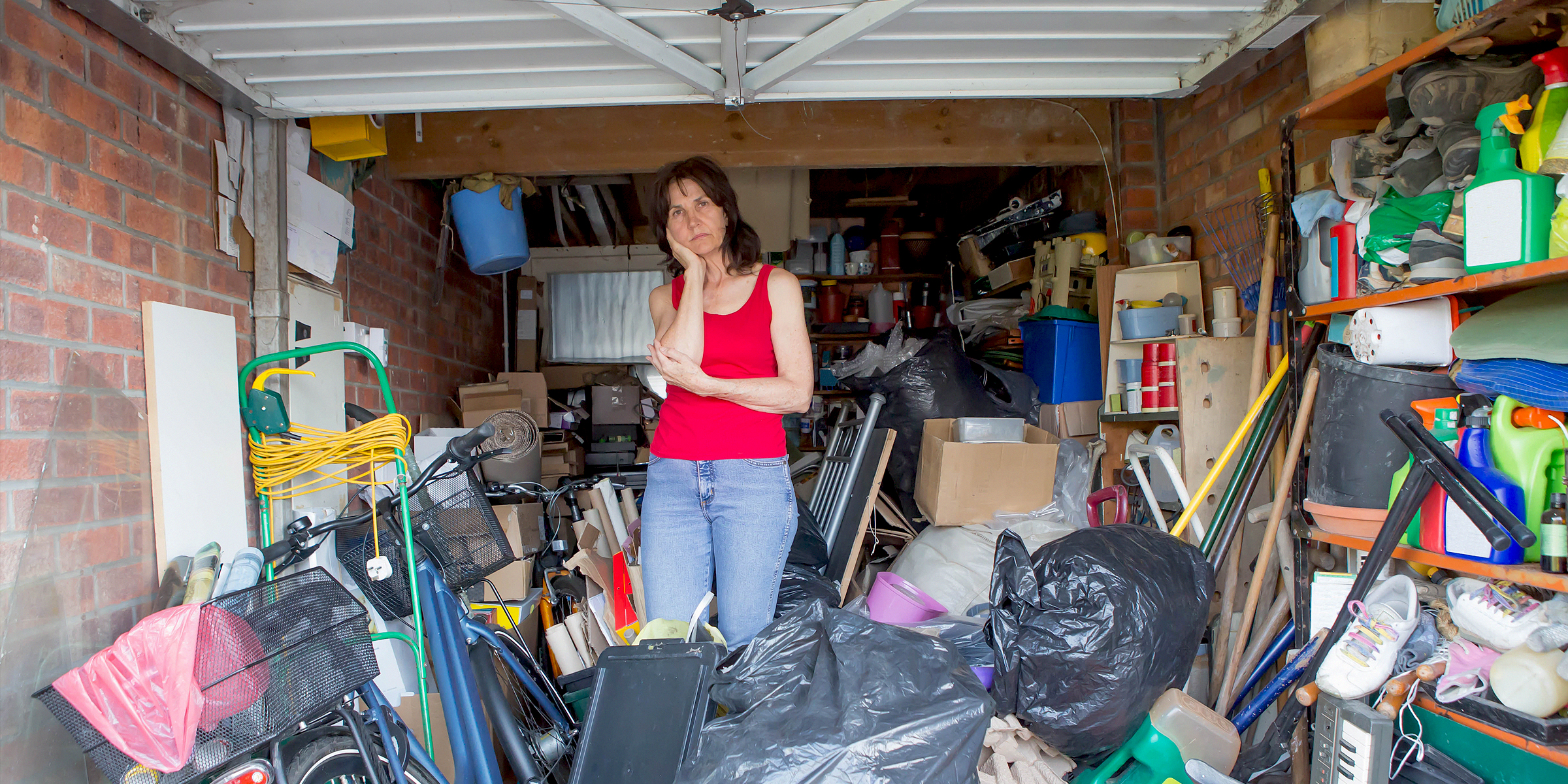 A woman standing in a garage filled with various items | Source: Shutterstock