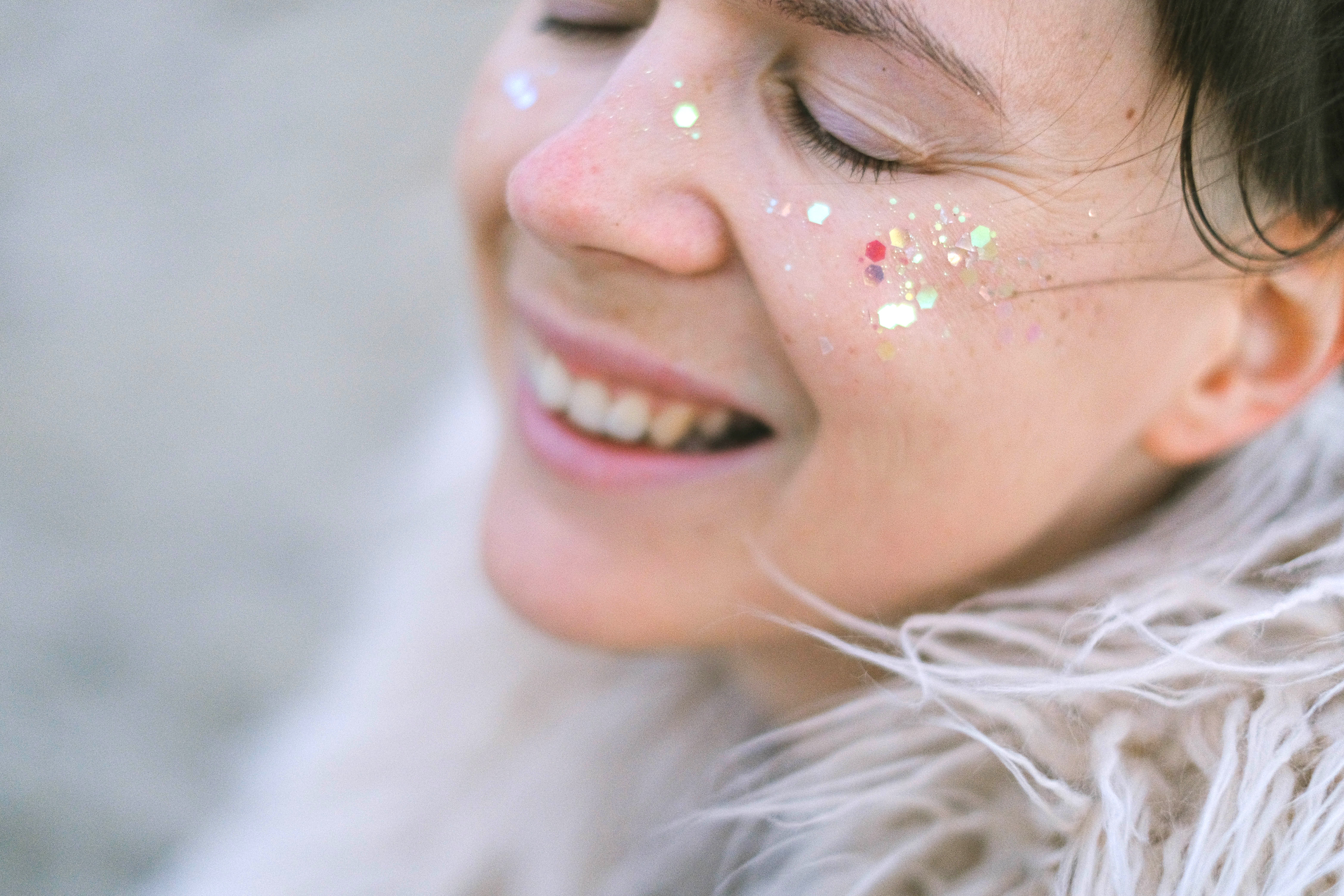 A laughing woman with glitter on her face. | Source: Pexels