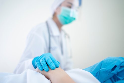 Enfermera con traje EPP cuidando a un paciente. | Foto: Shutterstock