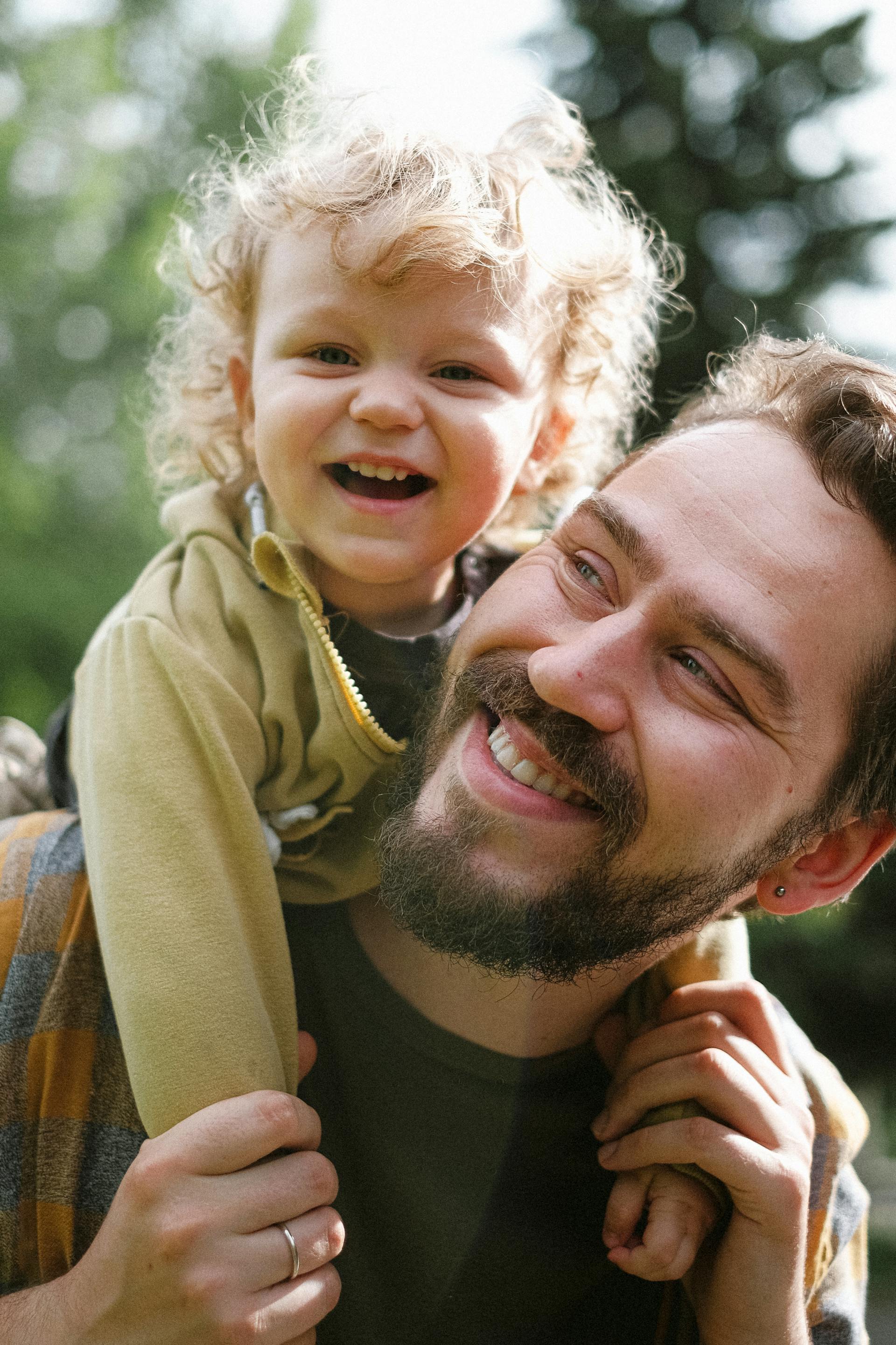 A man carrying his little boy on his shoulders | Source: Pexels