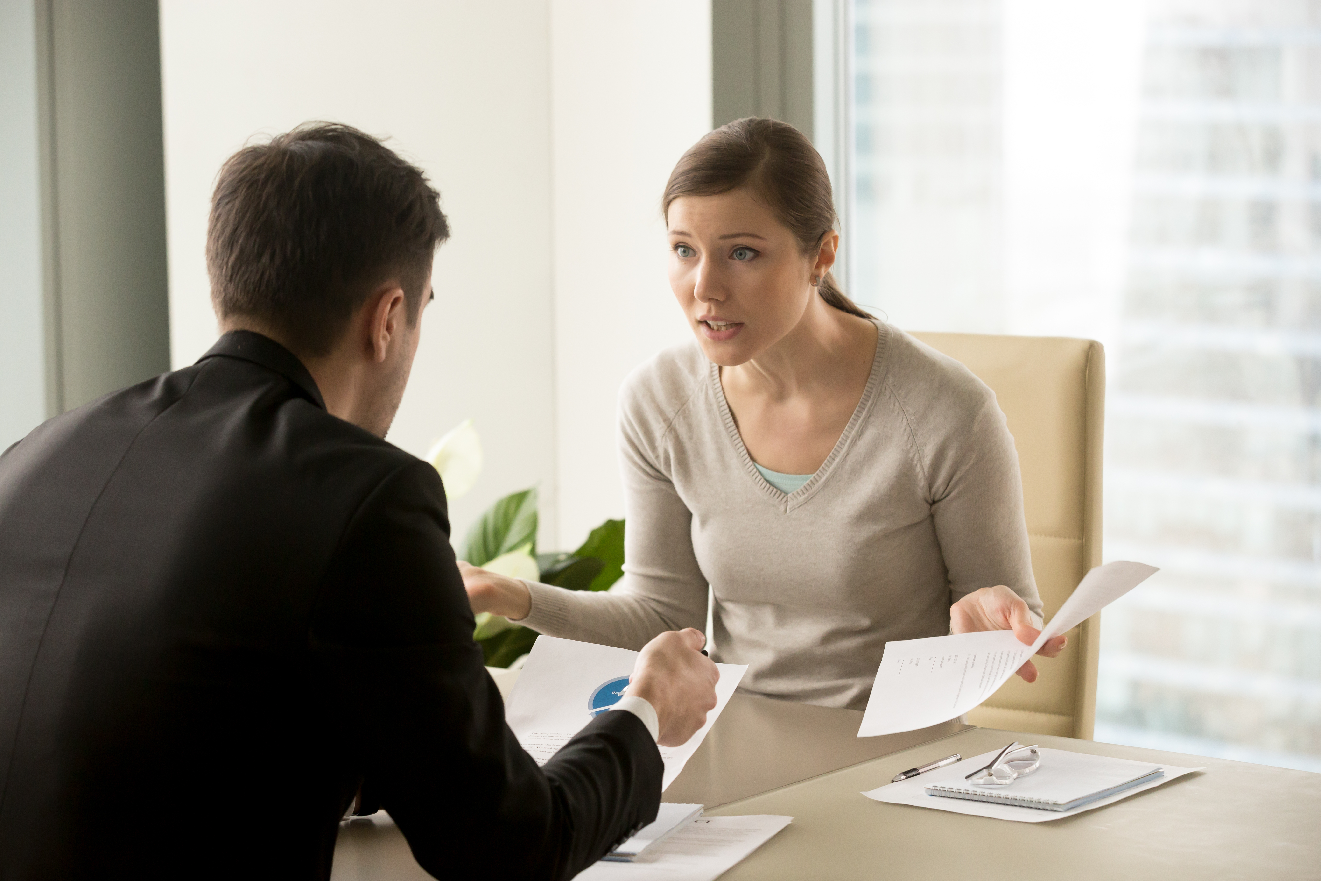 A woman arguing with a man in an office | Source: Shutterstock