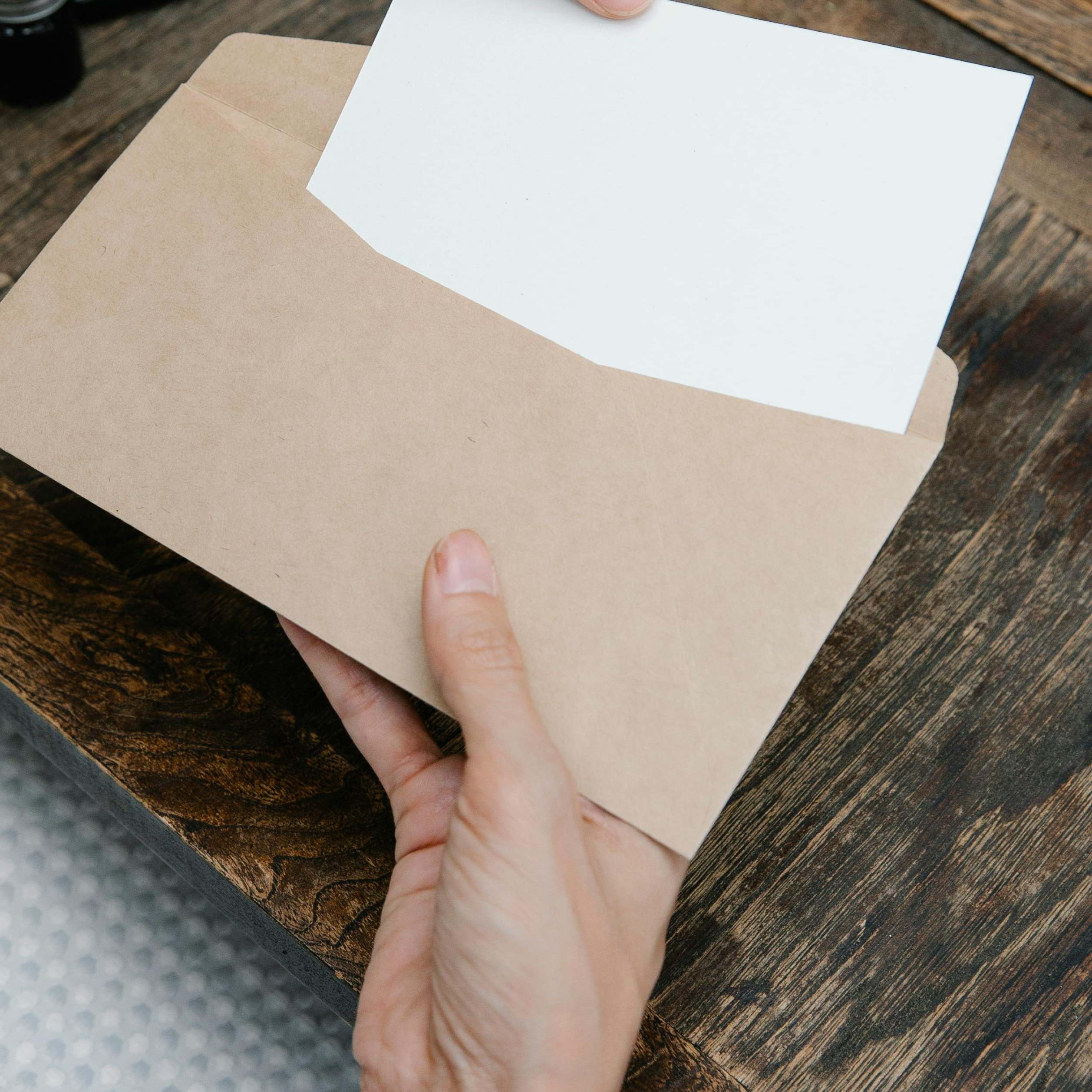 A woman extracting a document from an envelope | Source: Pexels