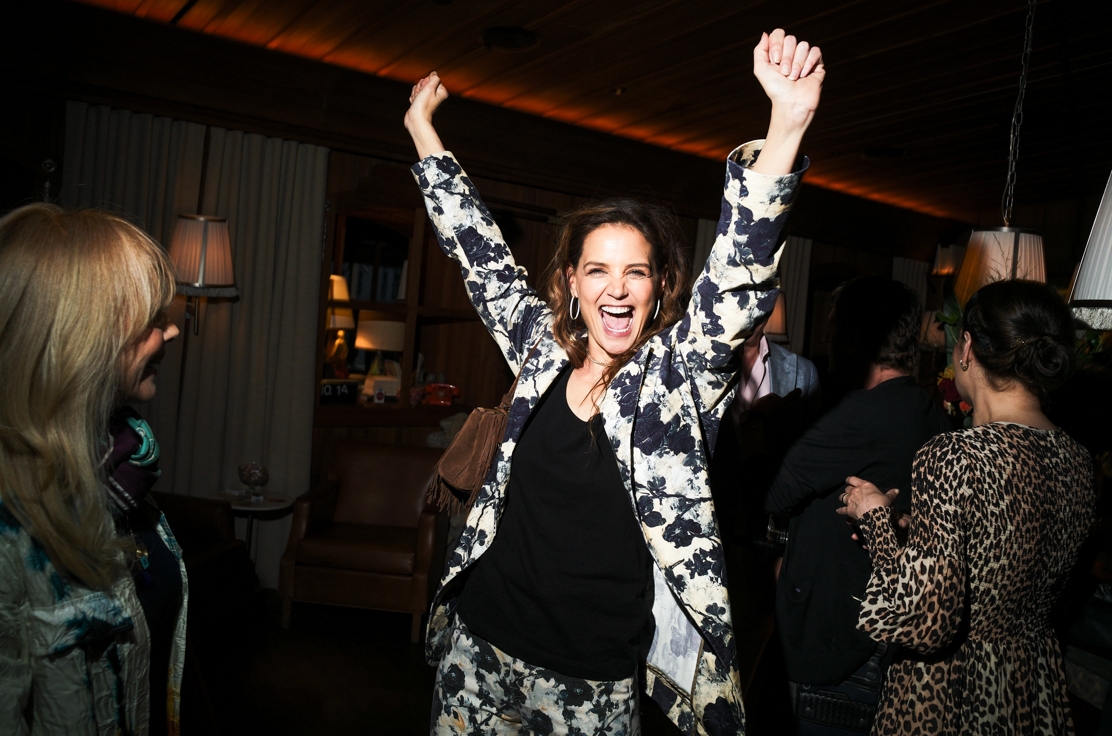 Katie Holmes smiling widely and throwing her arms up in the air. | Source: Getty Images