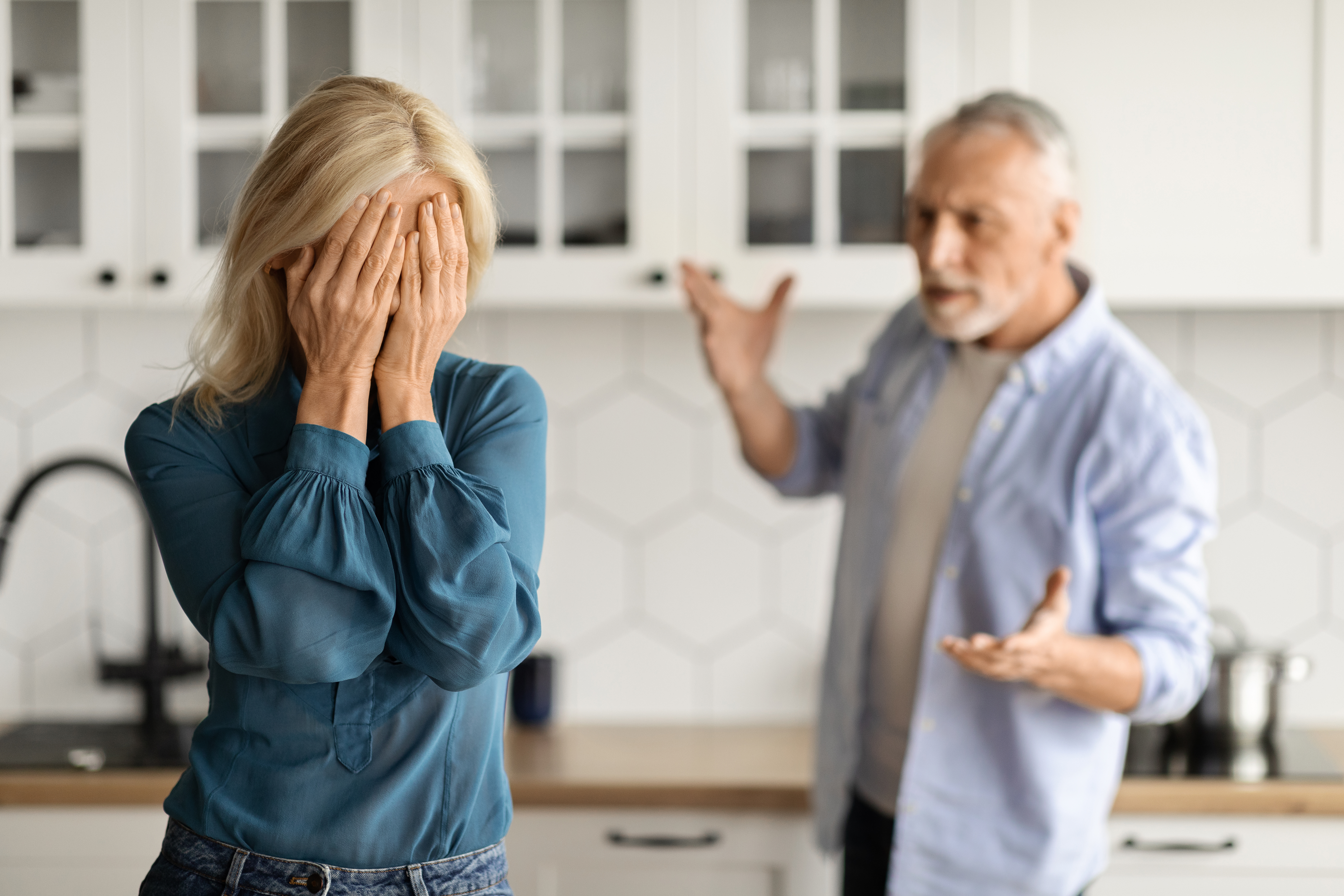 Angry husband standing in the background blaming his wife | Source: Getty Images