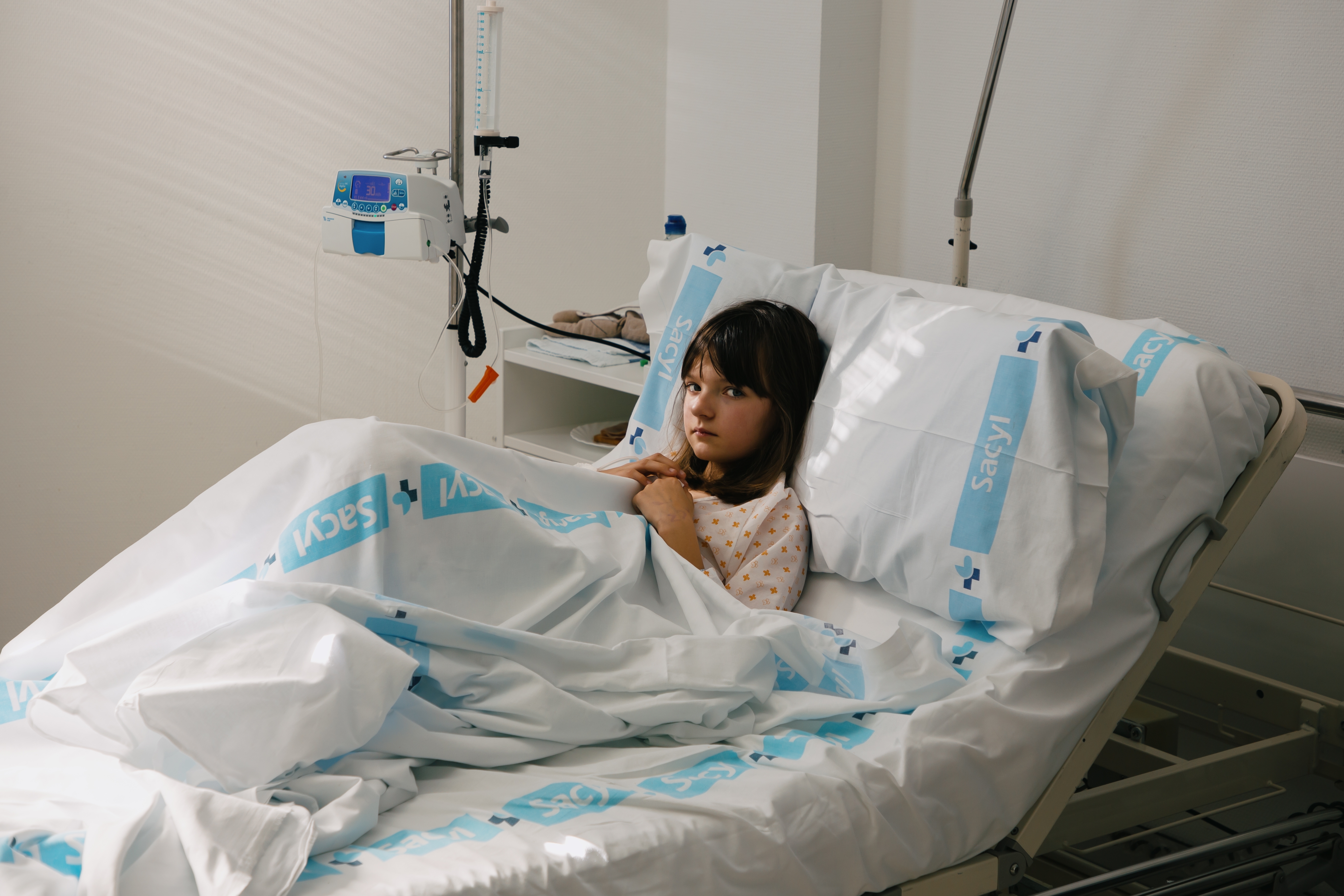 The girl lies on a hospital bed and looks at the camera | Source: Shutterstock.com