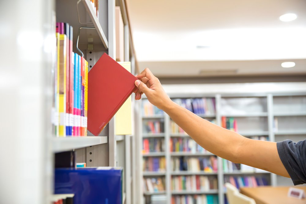 Hombre tomando un libro. | Foto: Shutterstock.