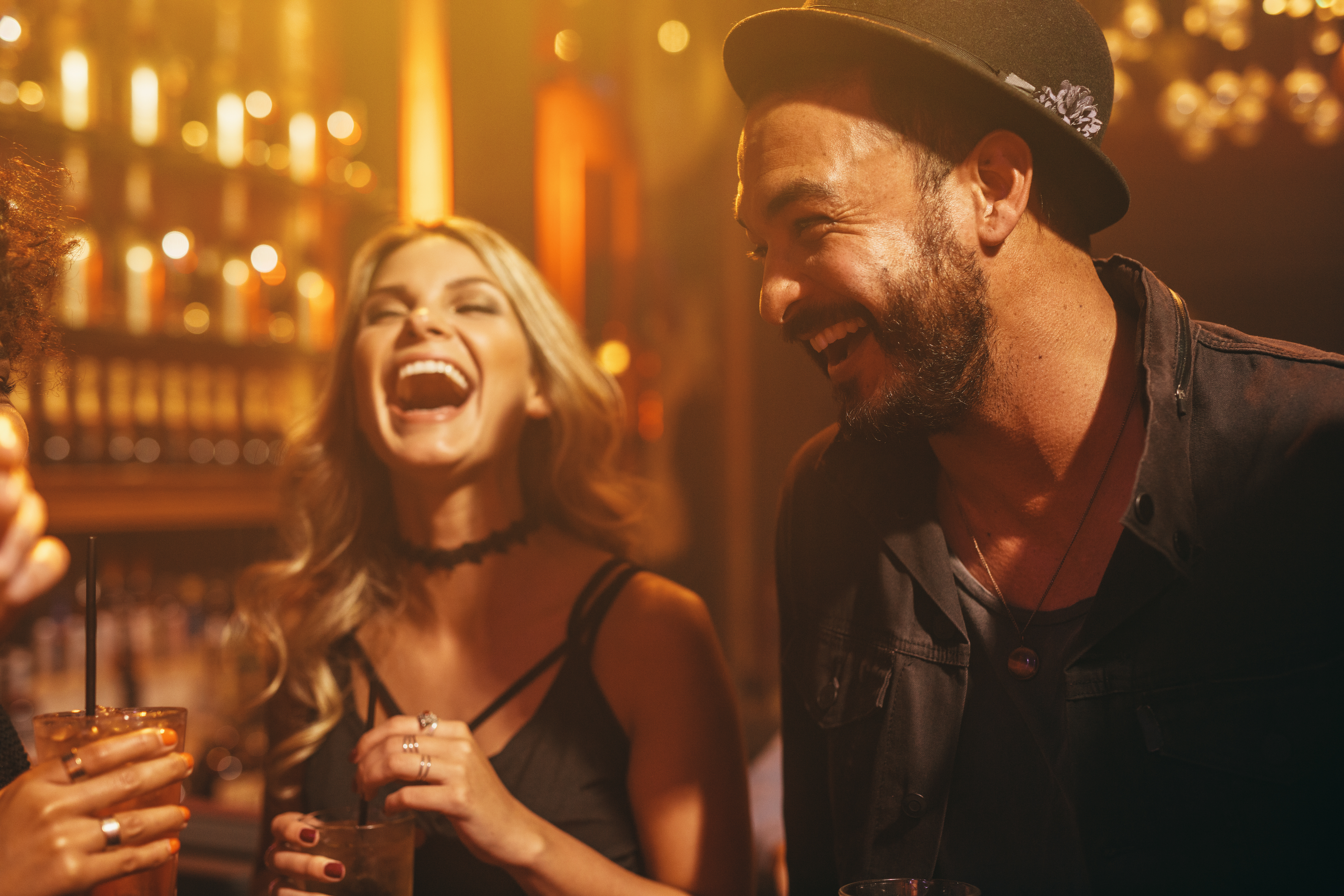 A man and woman laughing over drinks | Source: Shutterstock