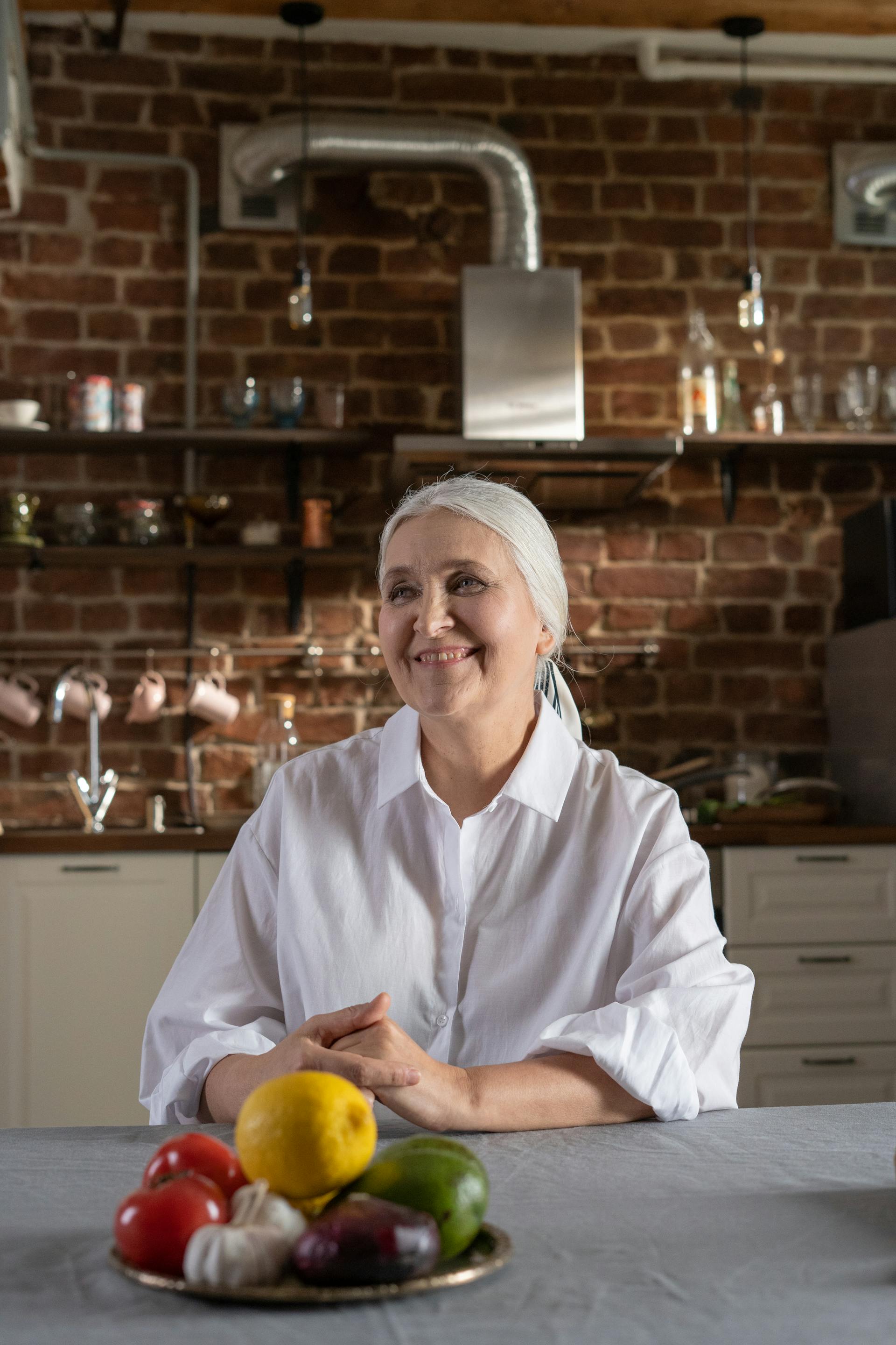 An older woman sitting at a table | Source: Pexels